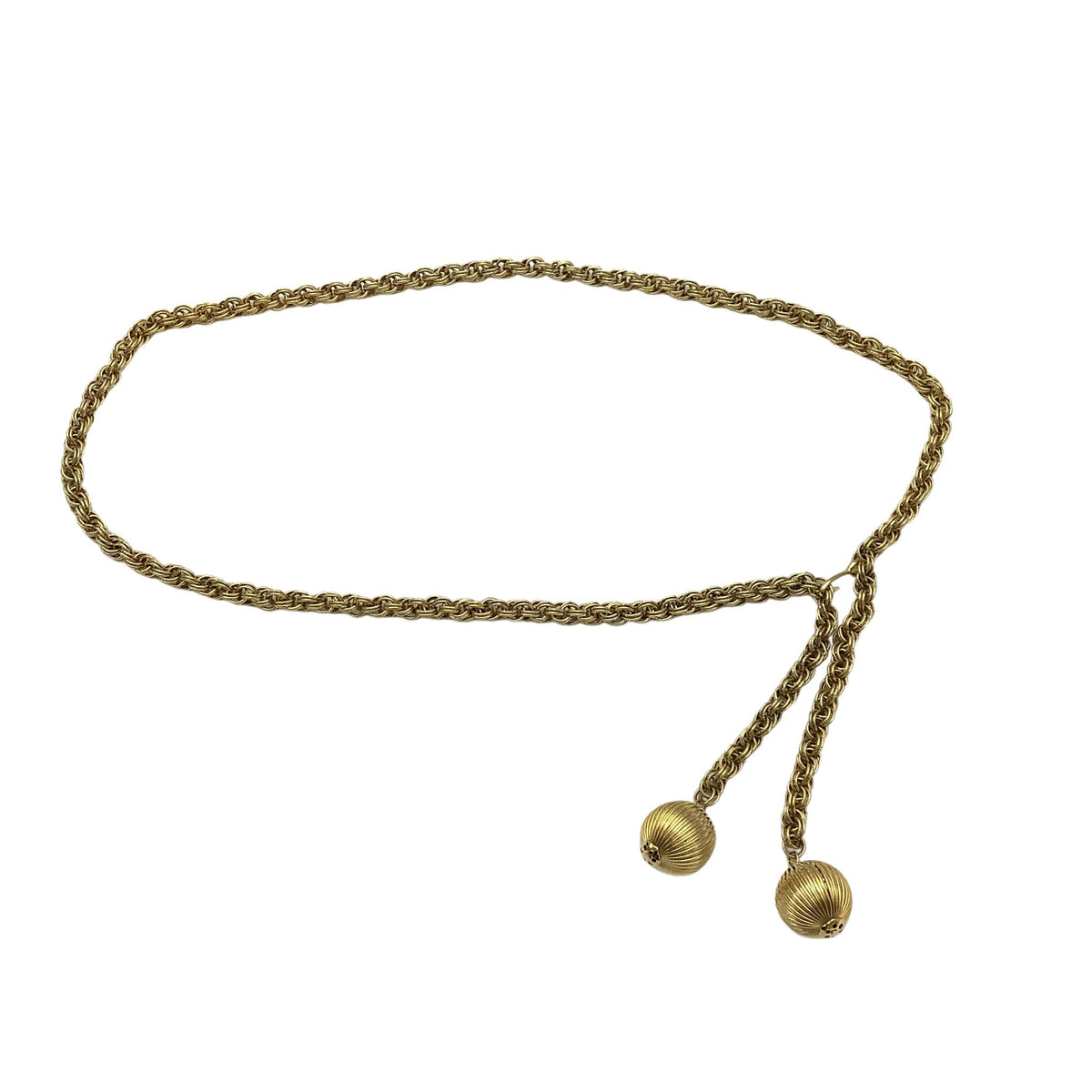 A vintage go-go era gold-toned braided chain belt with two dangling ball tassels, displayed on a clean white background.