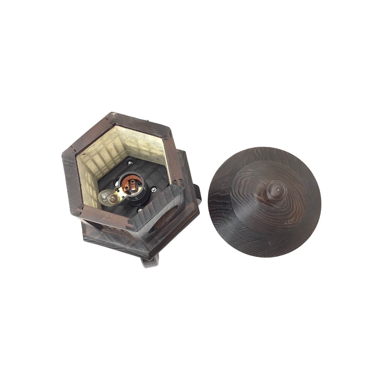 Interior of lamp with its lid off, showing a light-colored interior and a small central compartment where lightbulbs are placed.