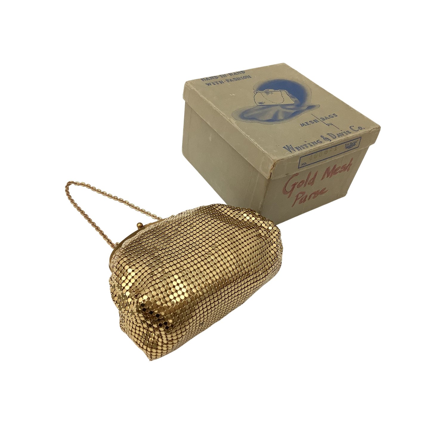 Side view of a vintage Whiting & Davis gold mesh clutch purse with a gold chain strap, shown next to its original cardboard box