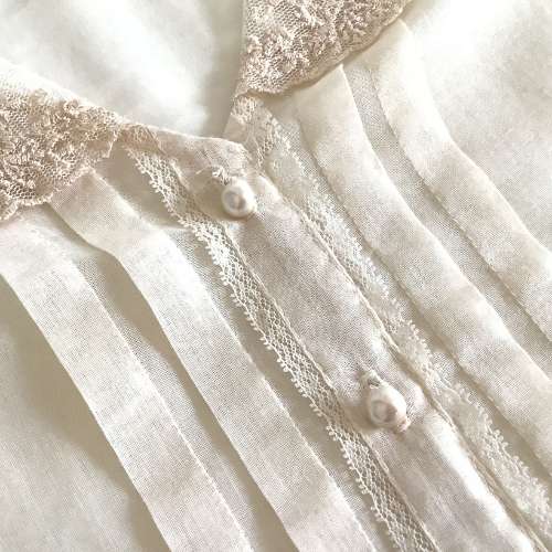 close-up of cream color lace blouse 