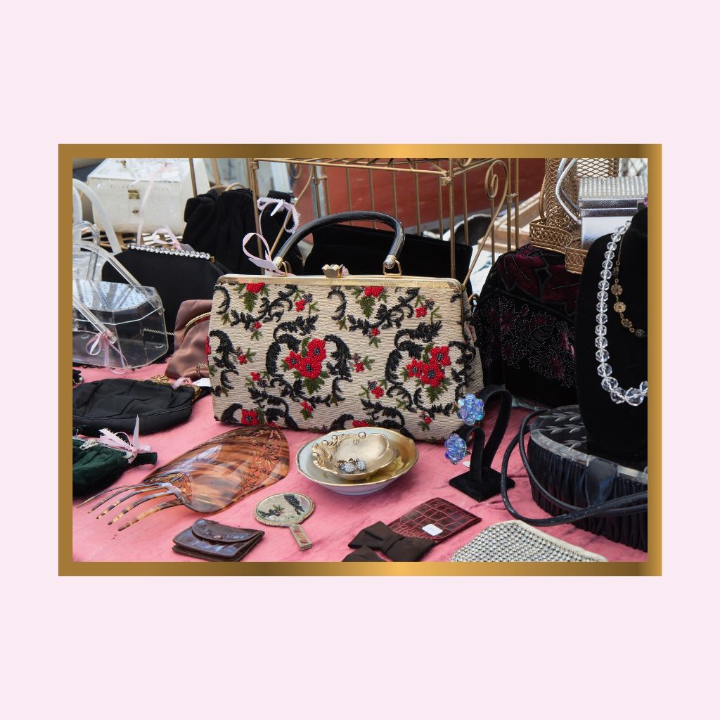 Collection of handbags and accessories on a pink surface