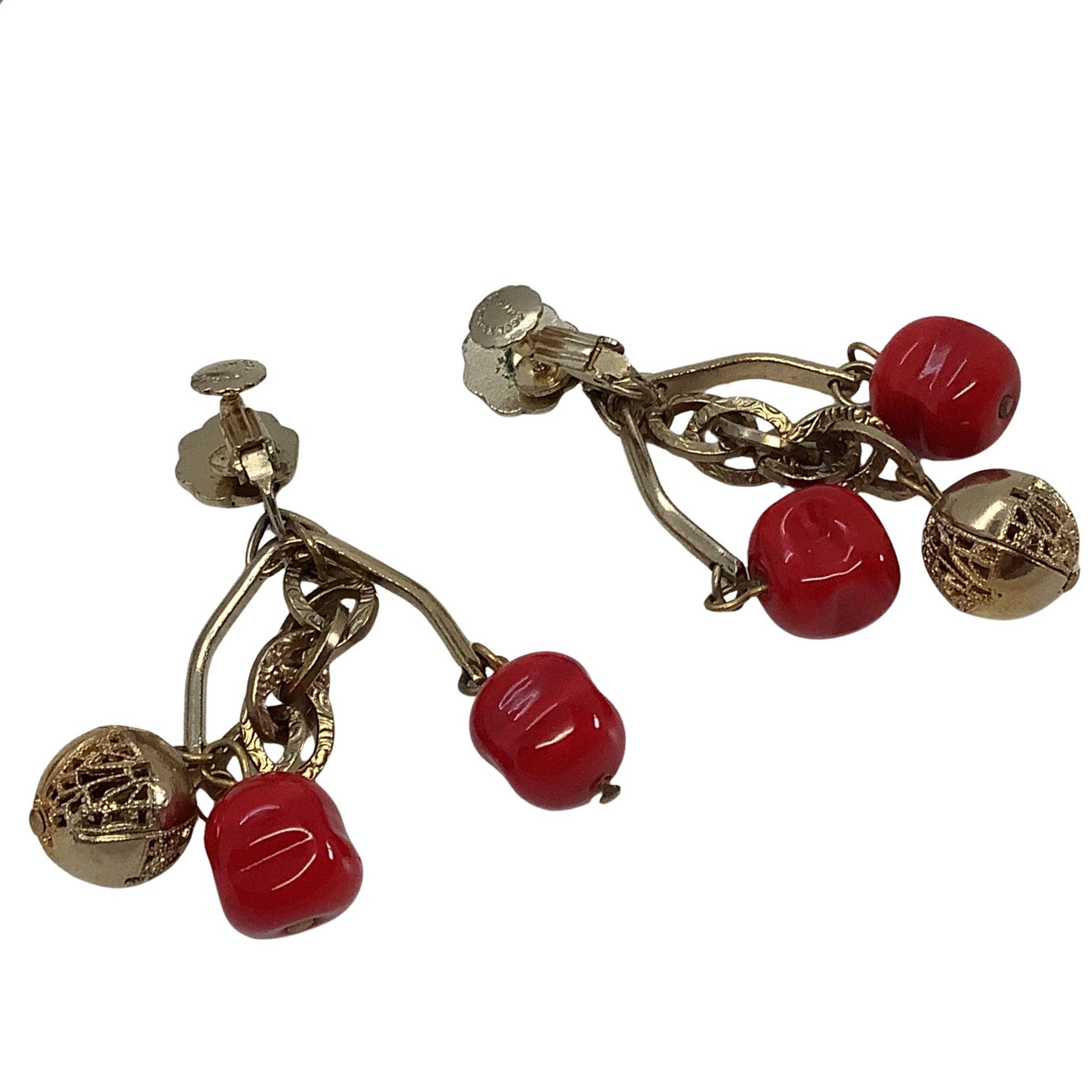 Gold earrings with red beads on a white background