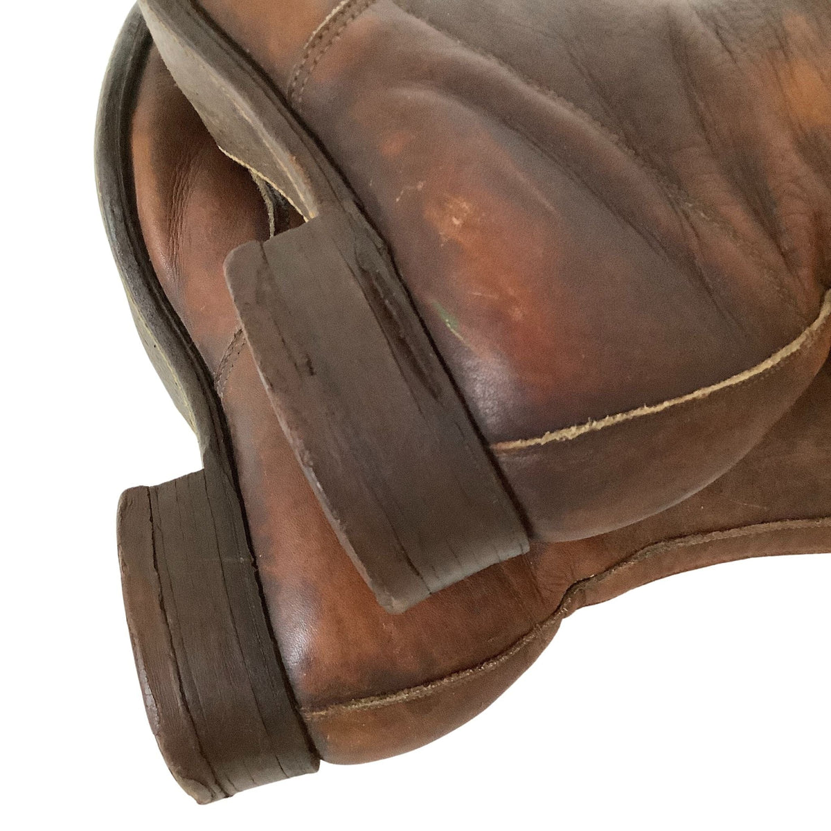 Stacked leather flat heel of antique brown boots showing deep scuff on side of heel.