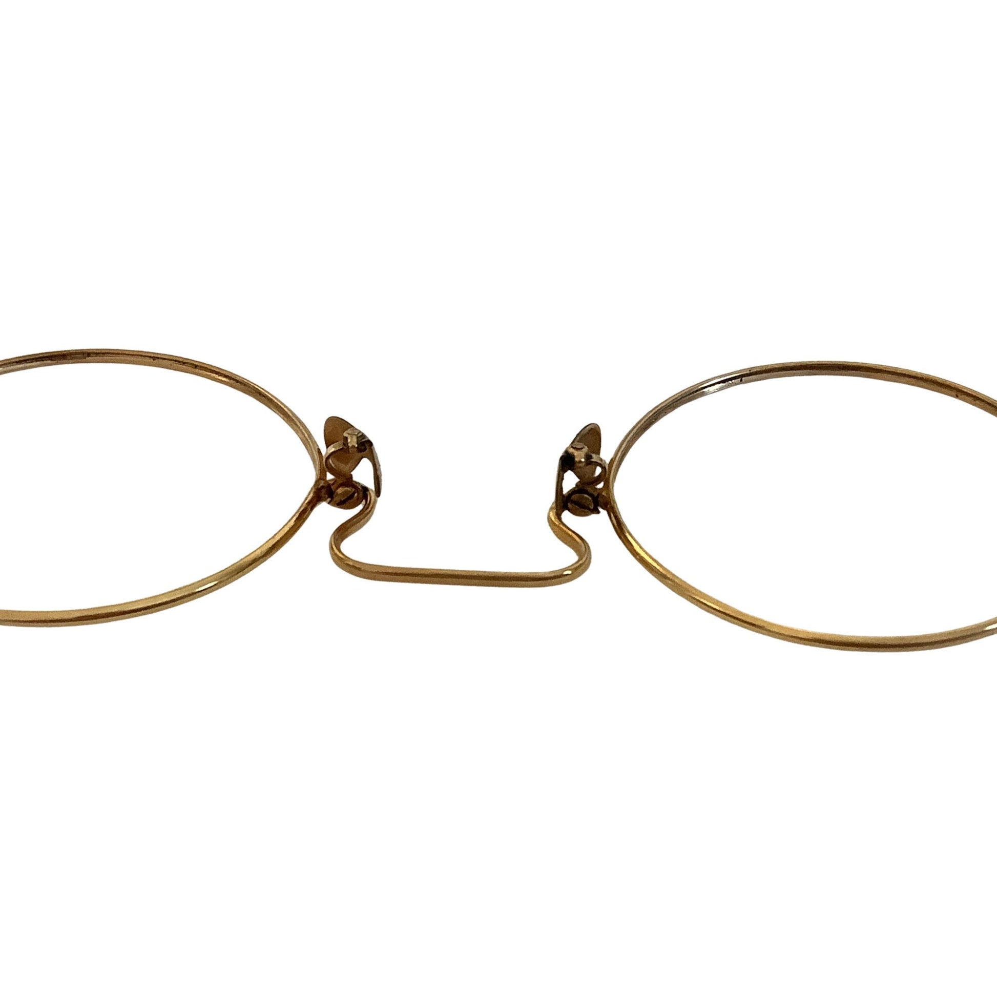 Pair of gold-rimmed eyeglasses close-up
