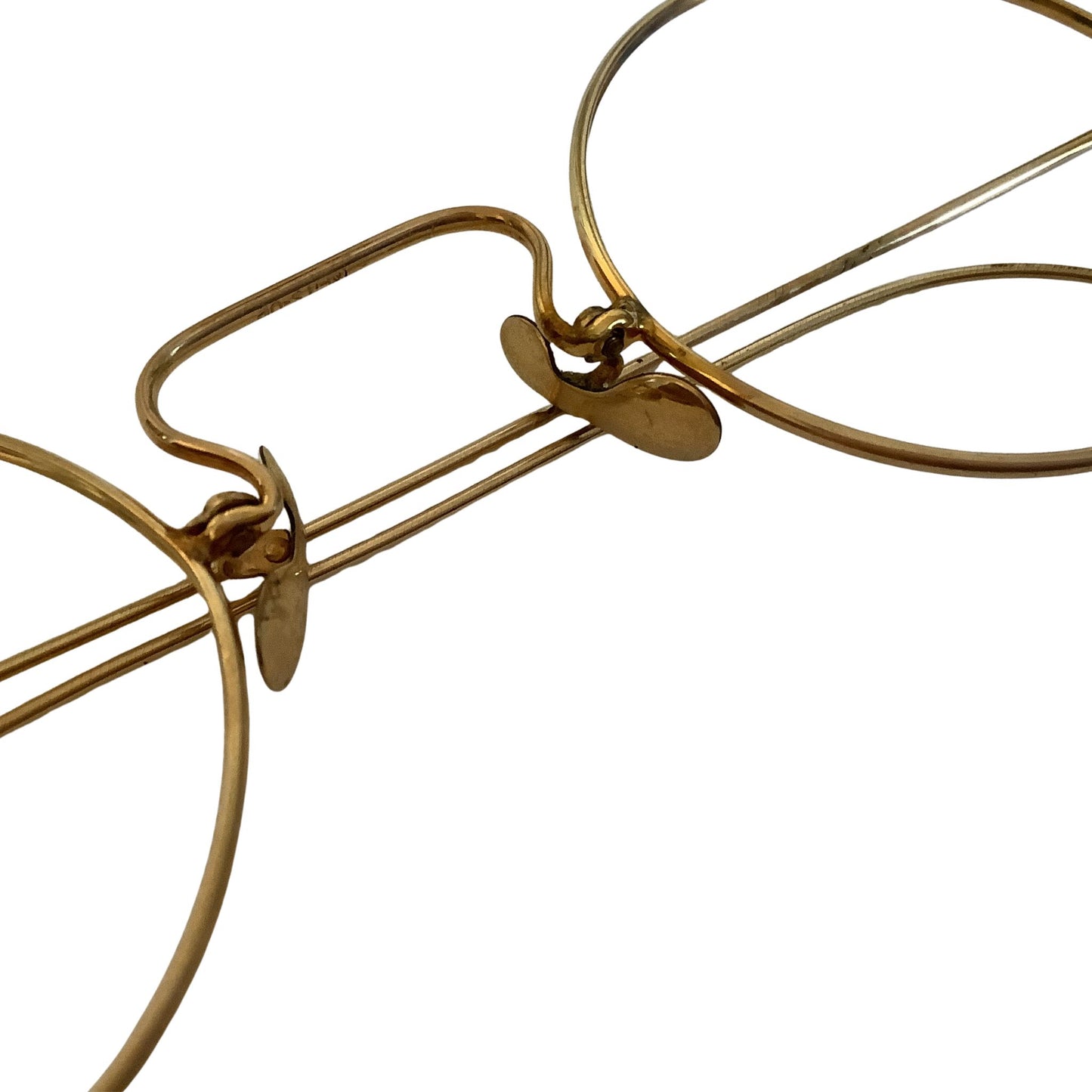 Close-up of gold eyeglasses nose bridge