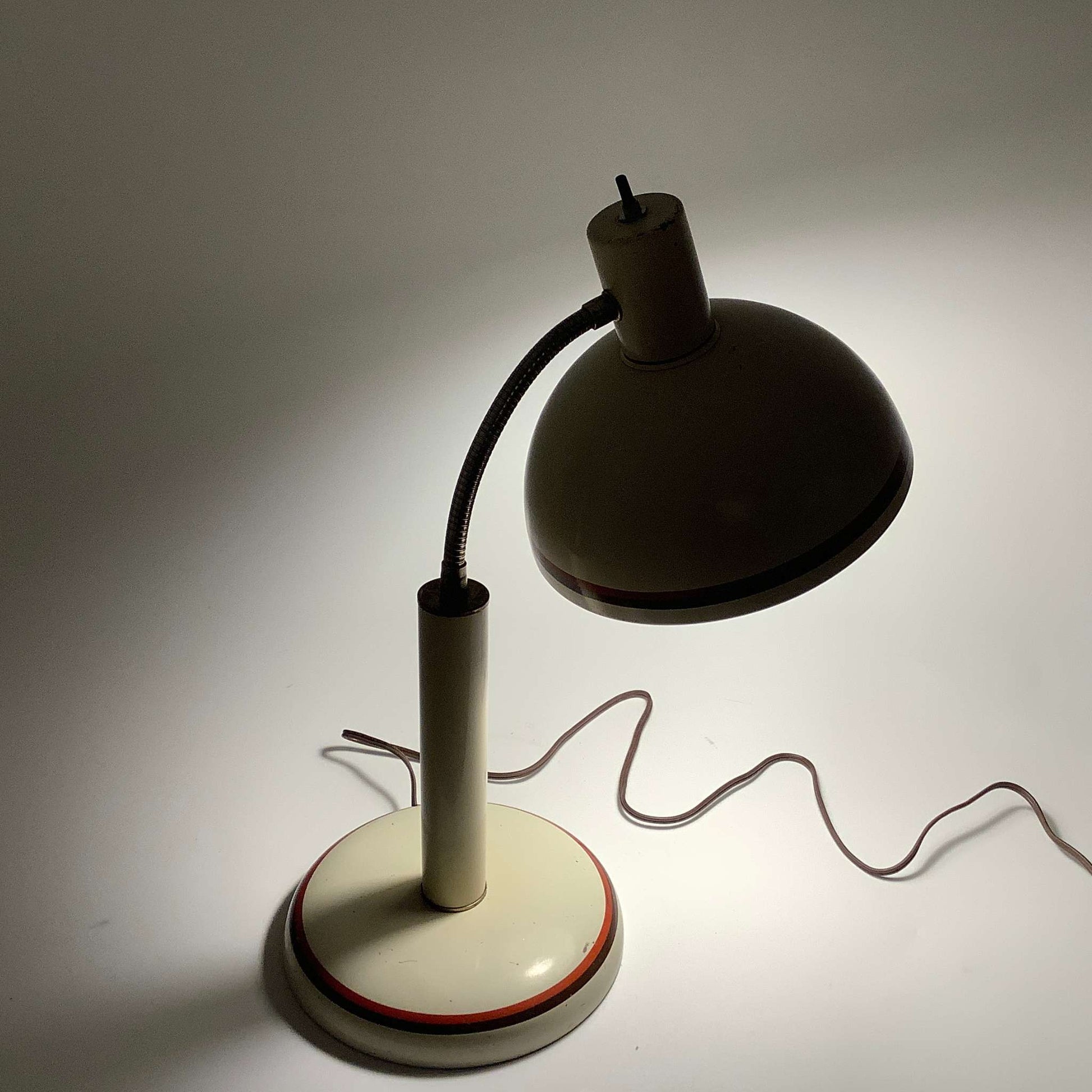 Lighted Bauhaus desk lamp in a shaded background