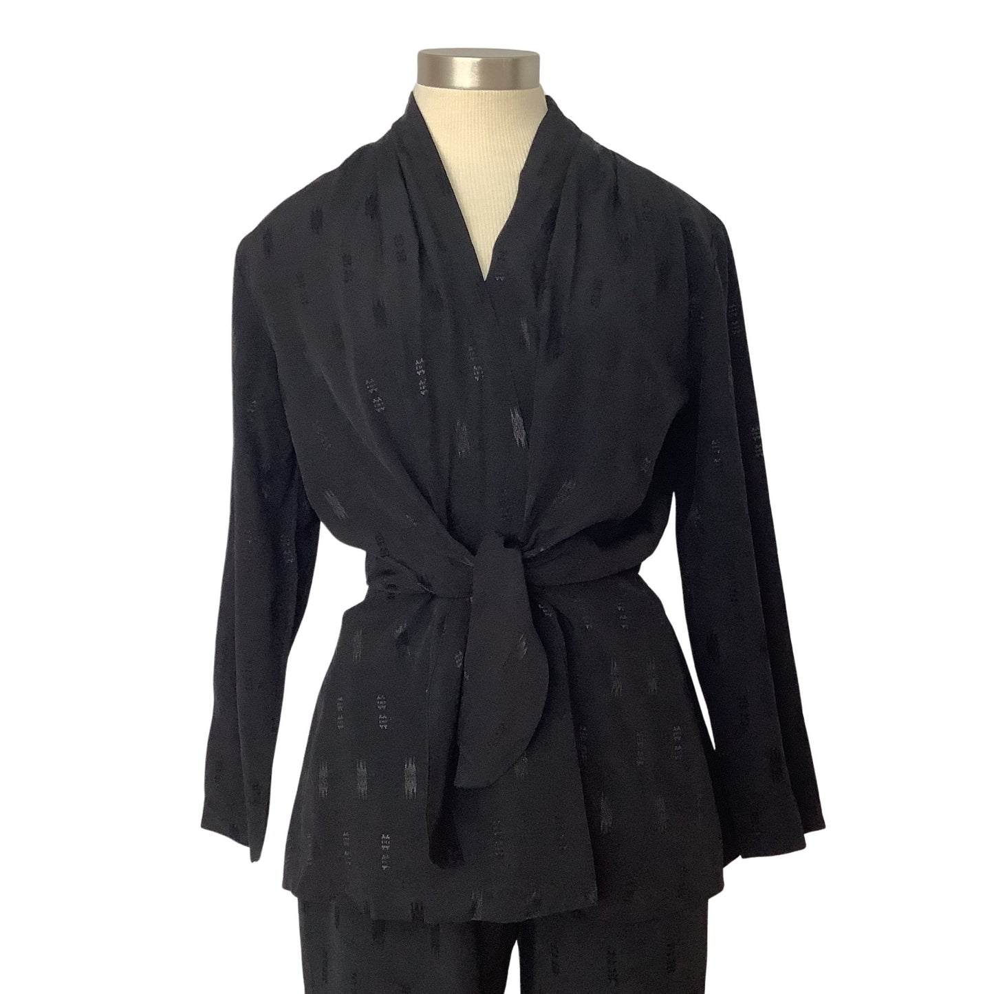 A black long-sleeve wrap-style top with a tie waist, displayed on a mannequin torso against a plain white background.