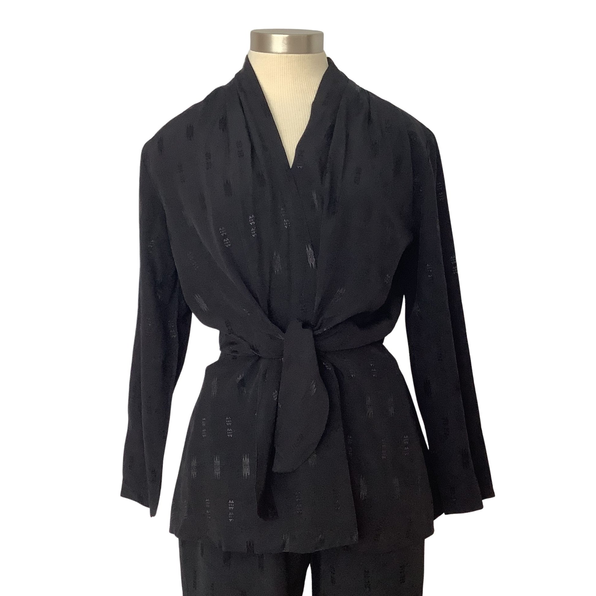 A black long-sleeve wrap-style top with a tie waist, displayed on a mannequin torso against a plain white background.