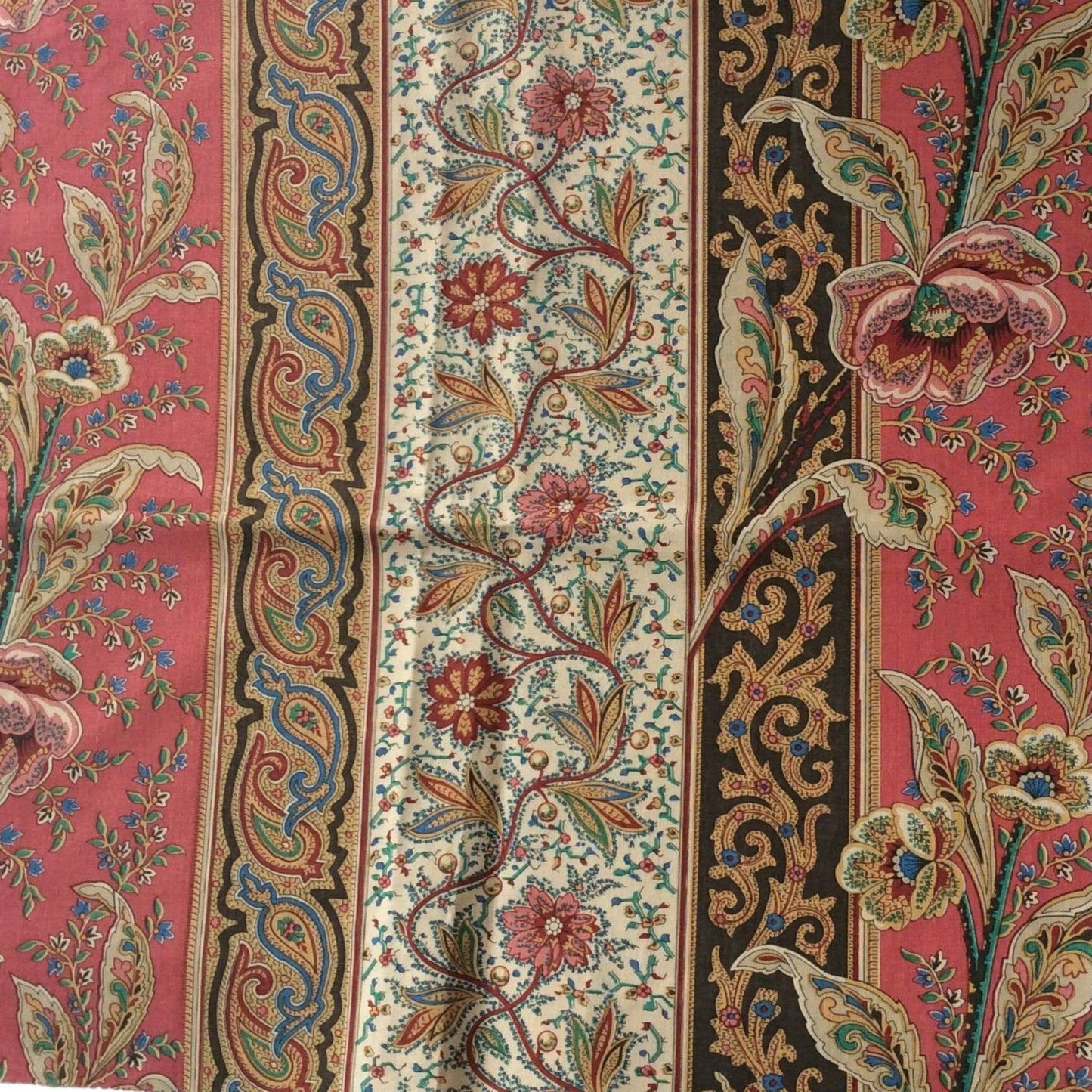 Top view of a patterned fabric with floral and colorful paisley designs