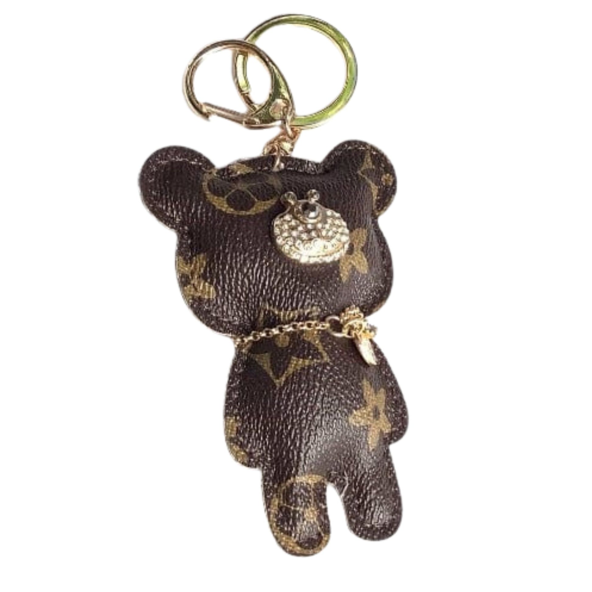 Brown teddy bear keychain with gold accents on a white background