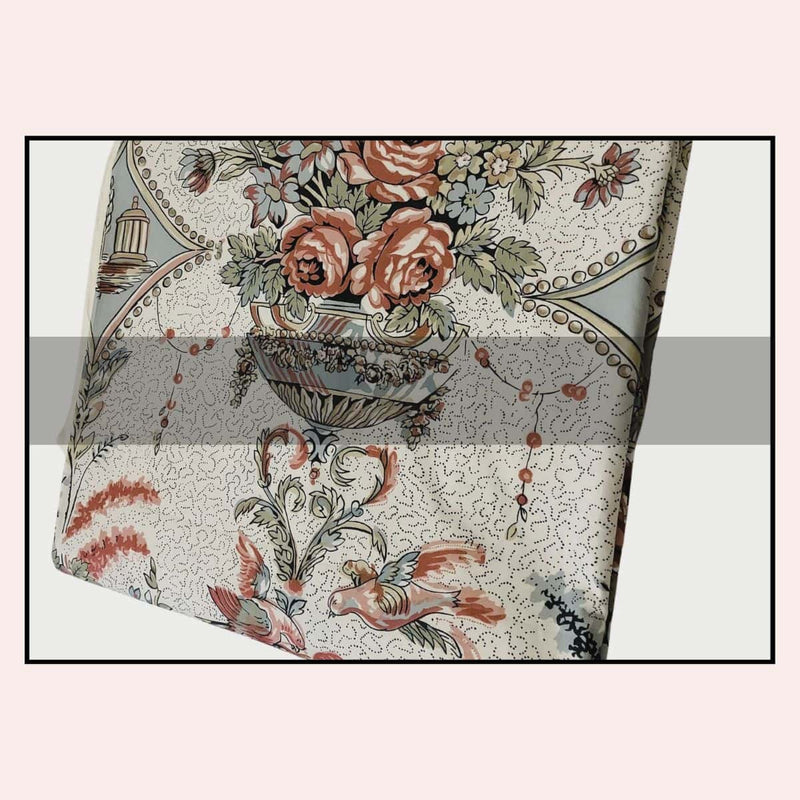 Decorative fabric with floral and paisley patterns on a light pink background