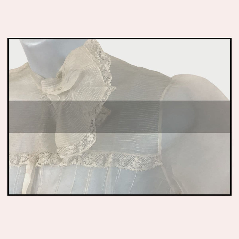 Light-colored blouse with lace details on a mannequin against a light background