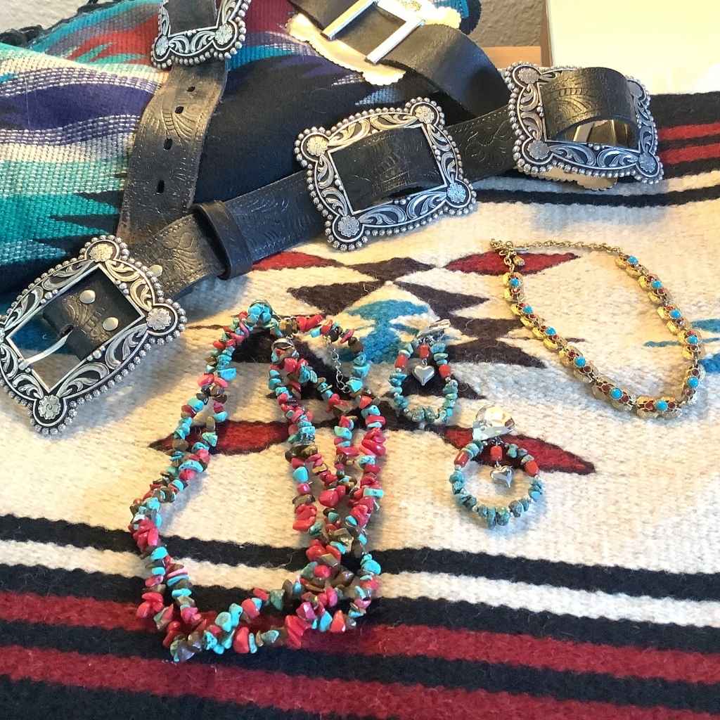 Western Belt and jewelry set on a patterned fabric background