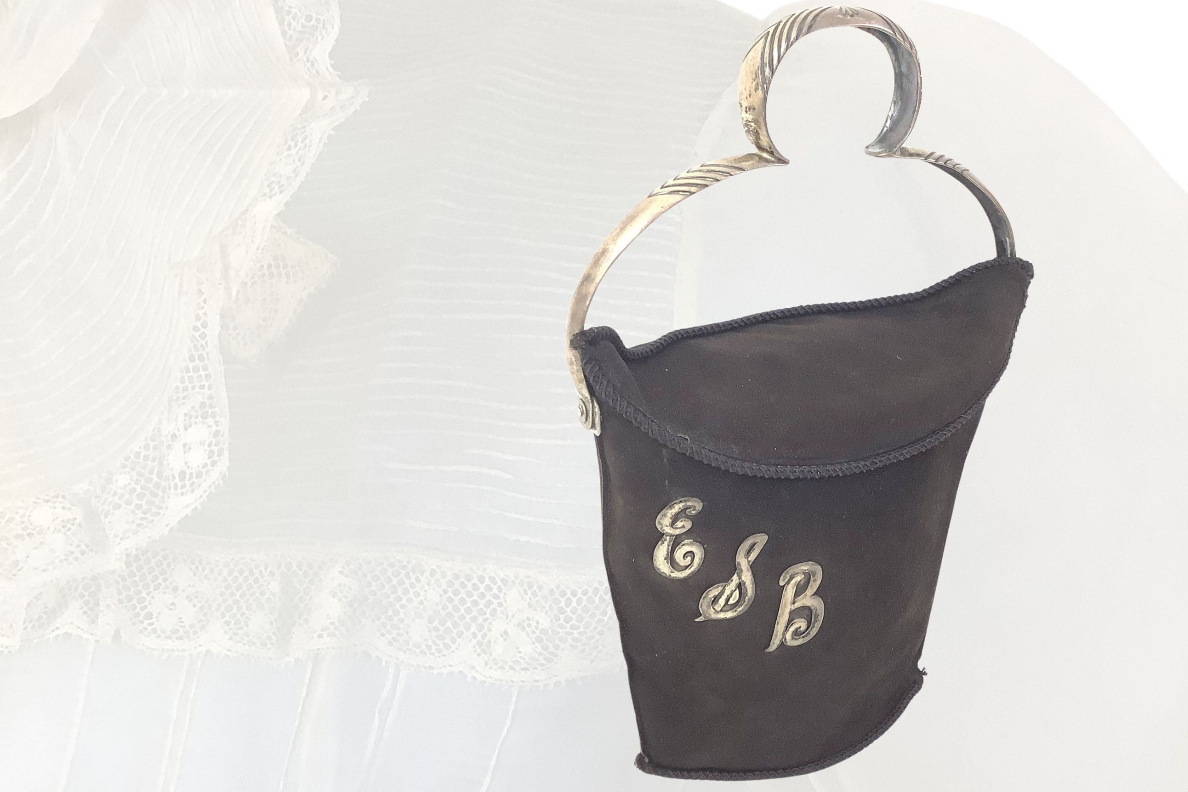 Black 1900s Handbag with sterling silver handle and monogram letters with beige faded antique blouse background