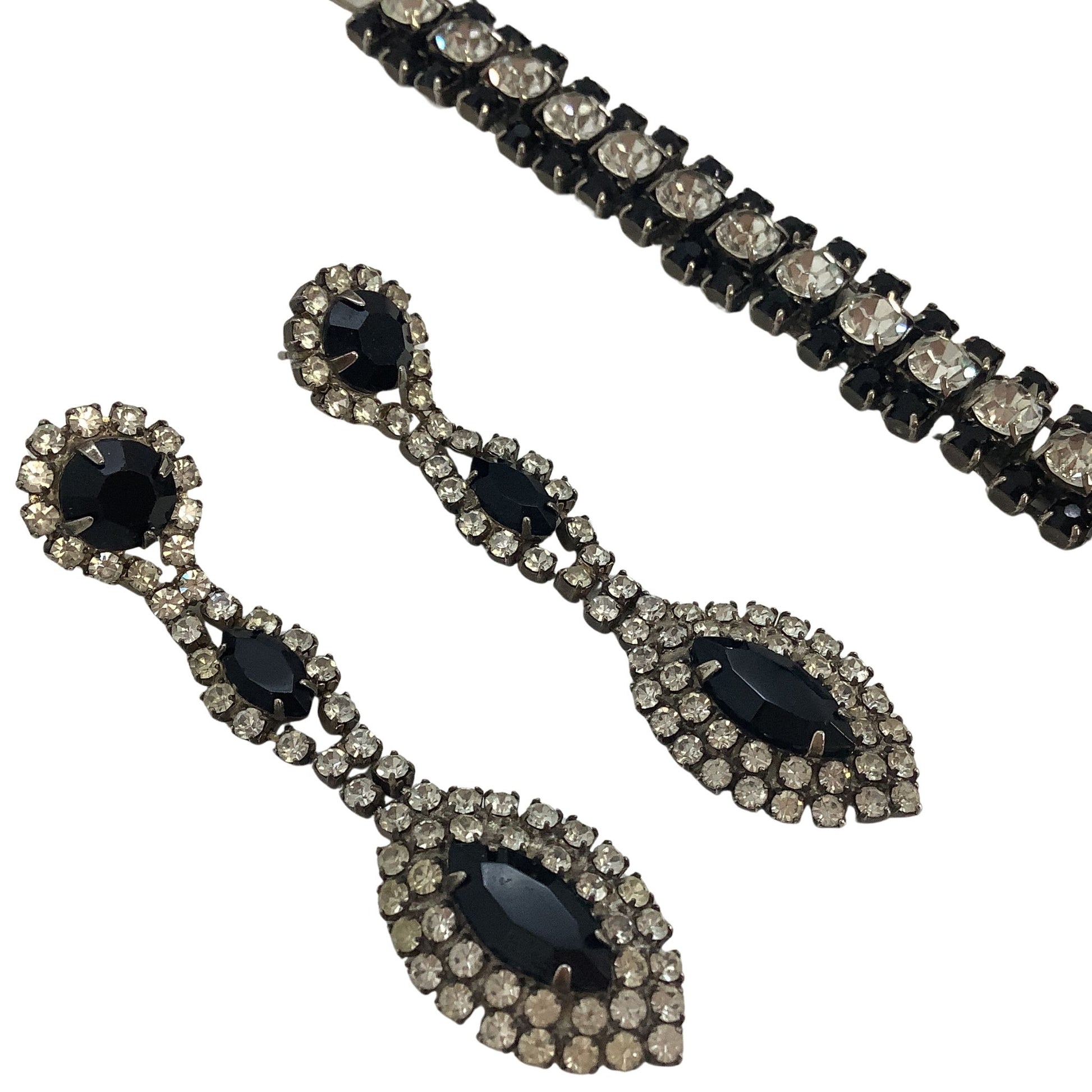 Pair of black teardrop earrings with clear gemstones on a white background