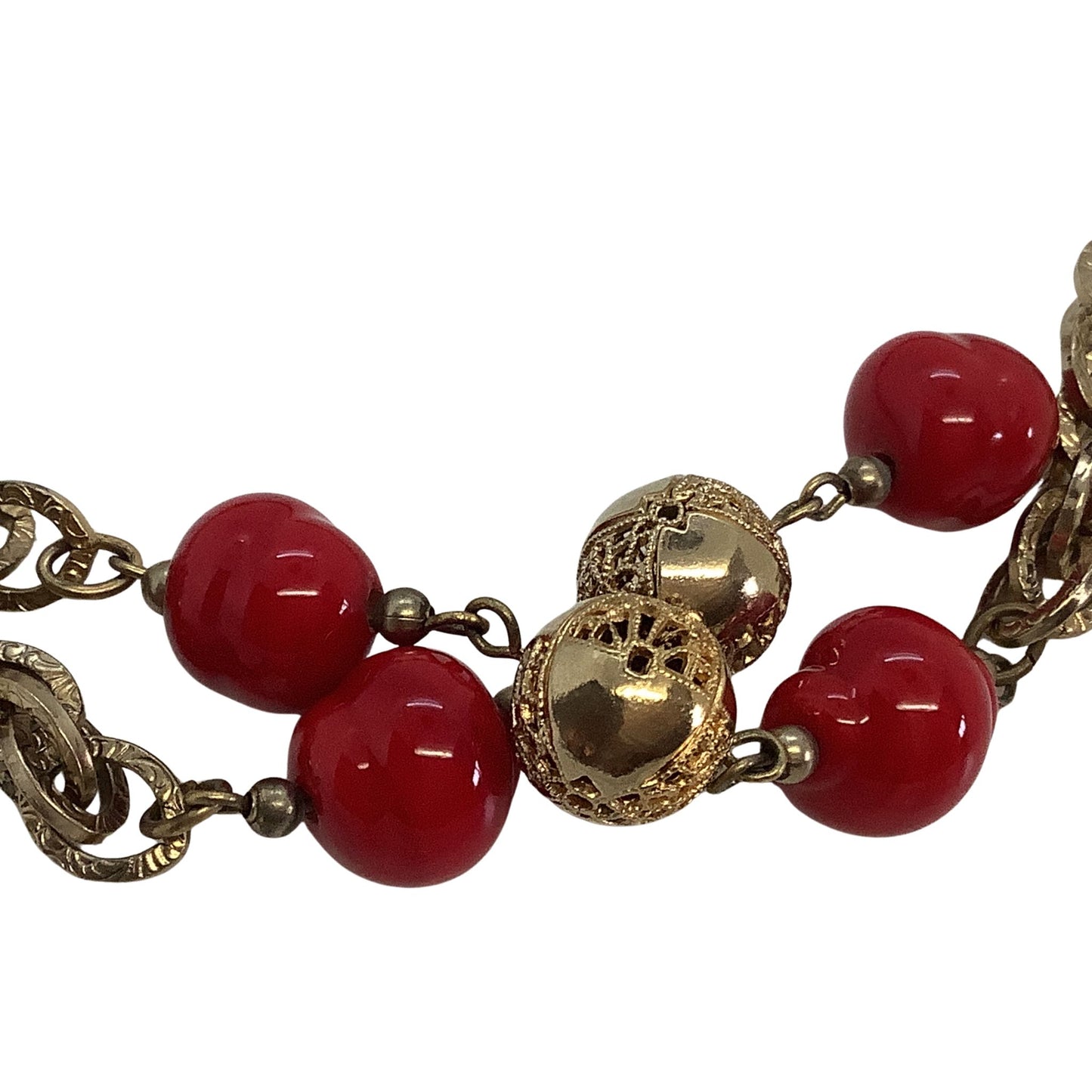 Closeup view of faux coral beads and gold chain on a white background