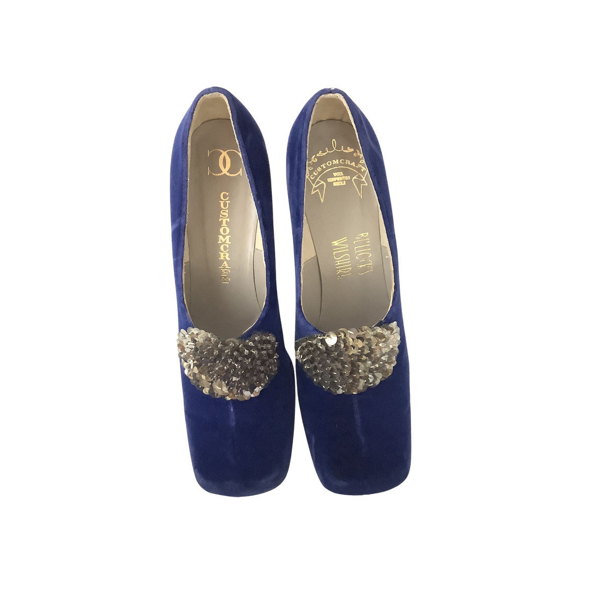 A pair of Custom Craft royal blue velvet heels with a silver sequin embellishment across the vamp, shown from a top-down view on a white background. The insoles display the brand.
