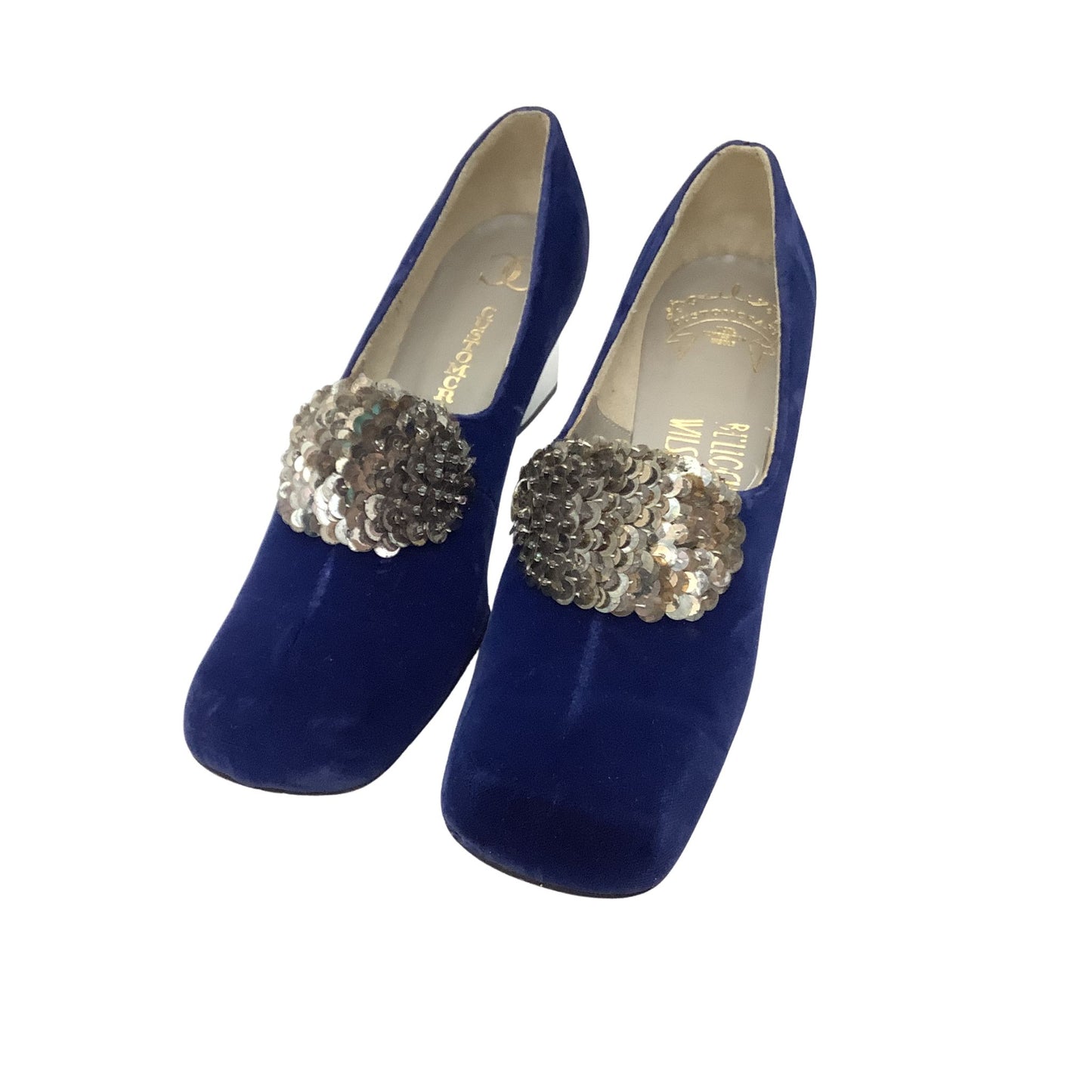 A pair of royal blue velvet Custom Craft pump shoes with a large, textured silver sequin embellishment across the vamp, shown on a plain white background.