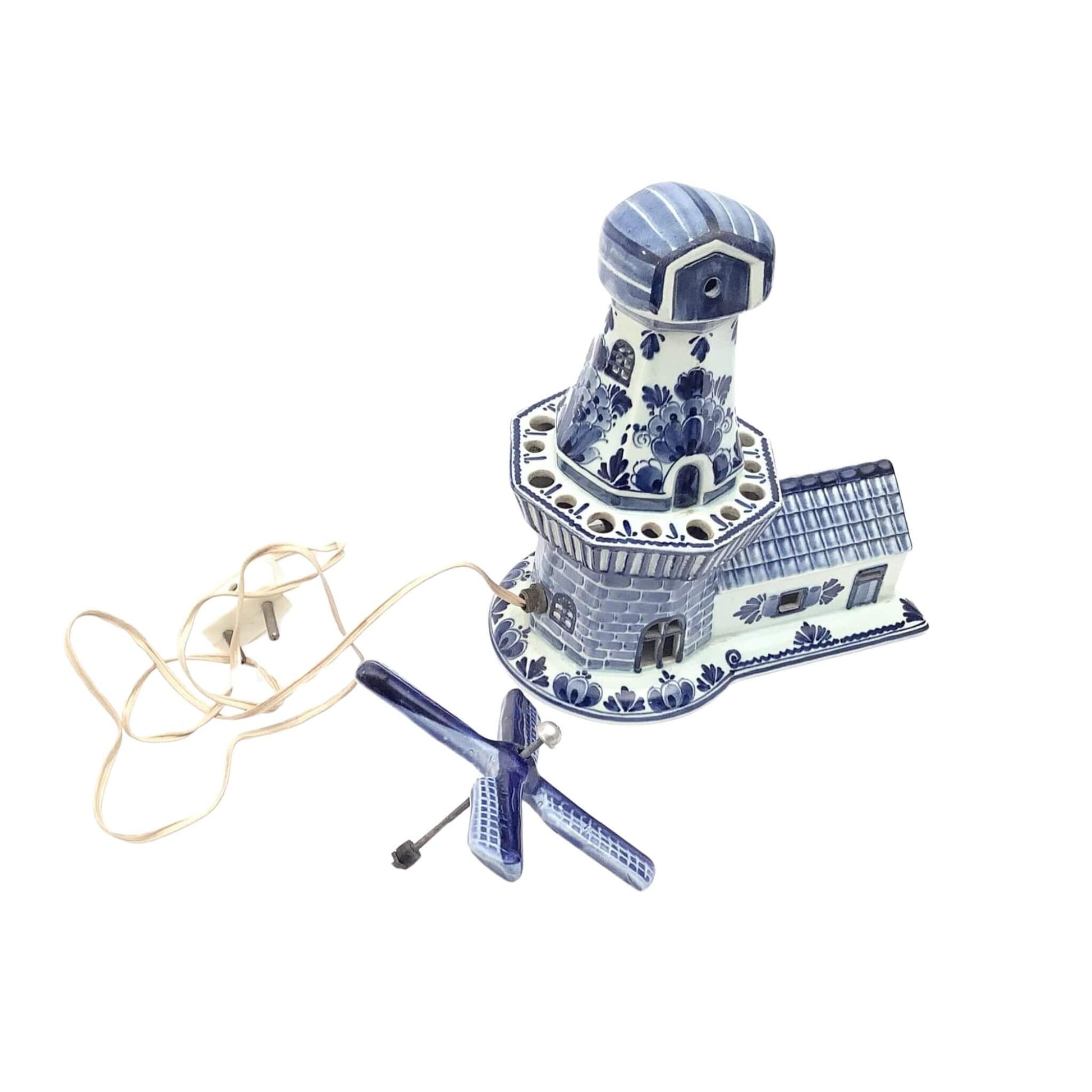 Decorative Delfts ceramic lighthouse lamp with blue and white design dissasambled on a white background