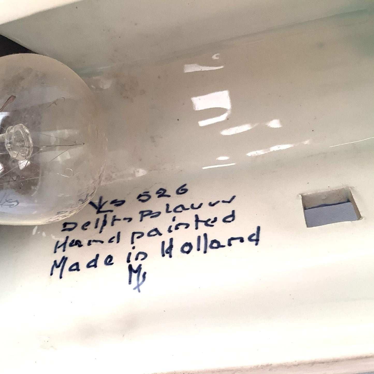 Delfts ceramic lamp close-up of handwritten signature view on a white background