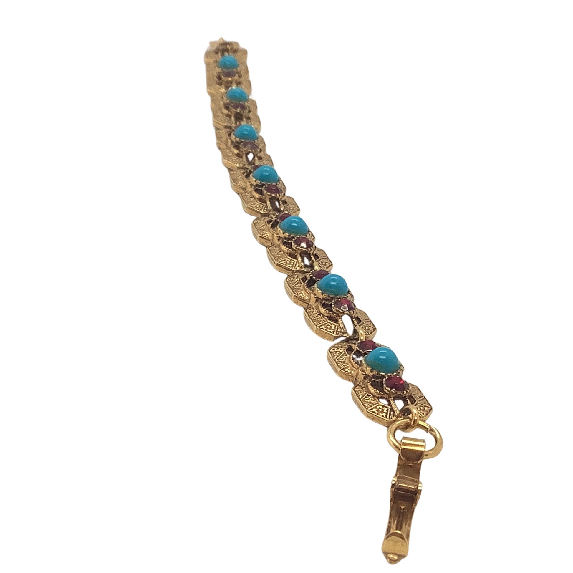 Elaborate gold tone metal bracelet side view showing detailed metalwork on a white background