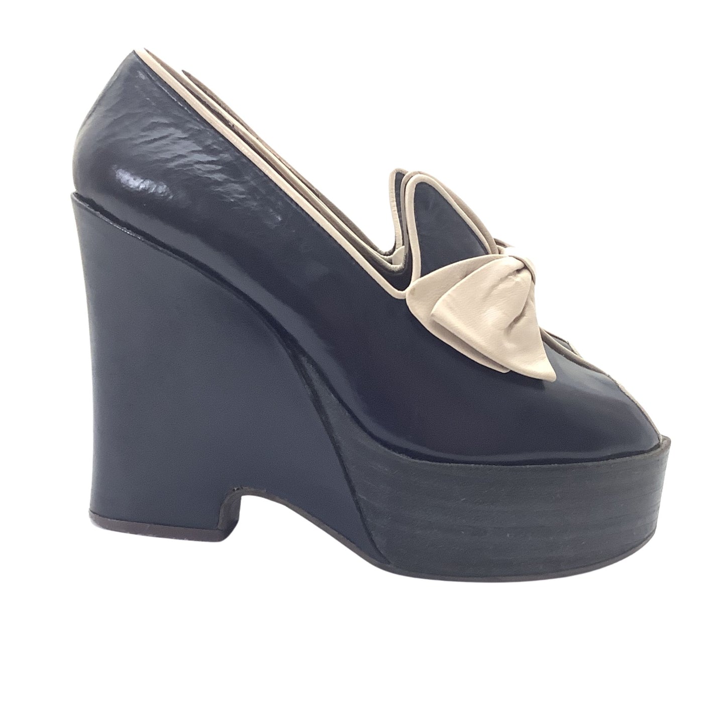 Vintage 1970s Elditas navy blue leather platform wedge shoes with a beige bow and trim, shown from a side profile.