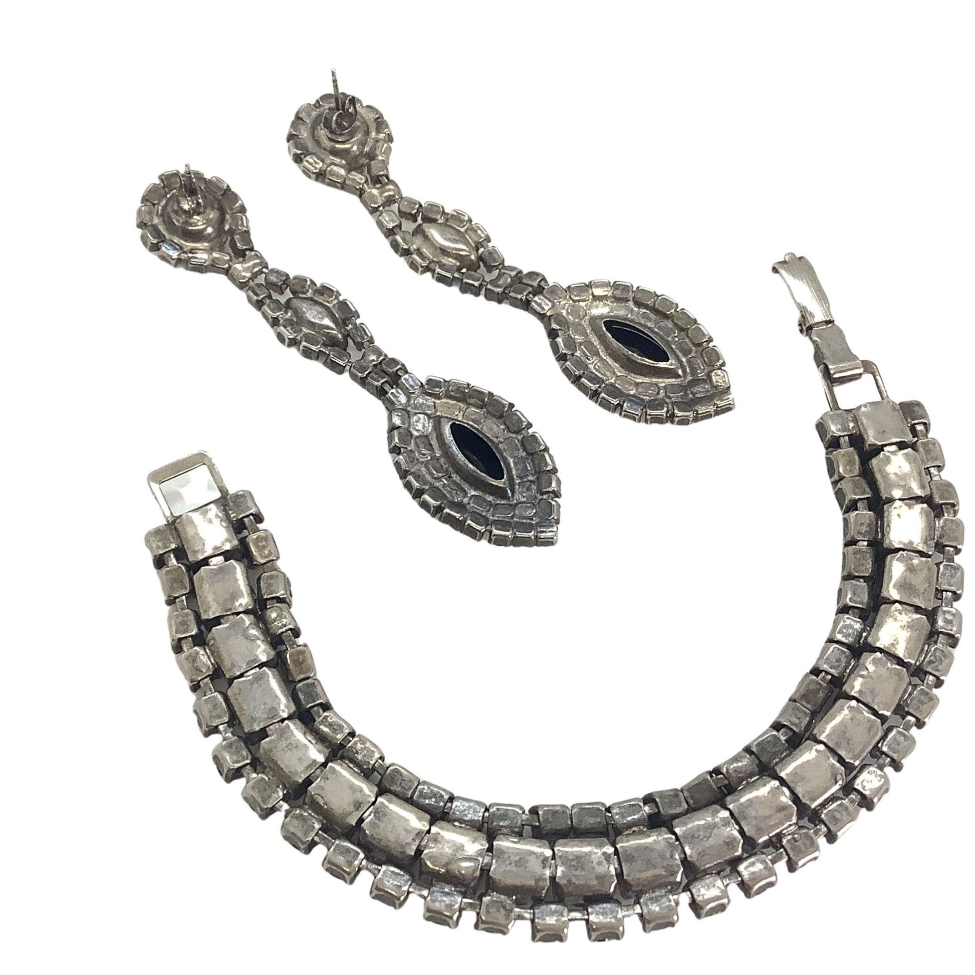 Back view silver-tone metal, bracelet, and earrings on a white background