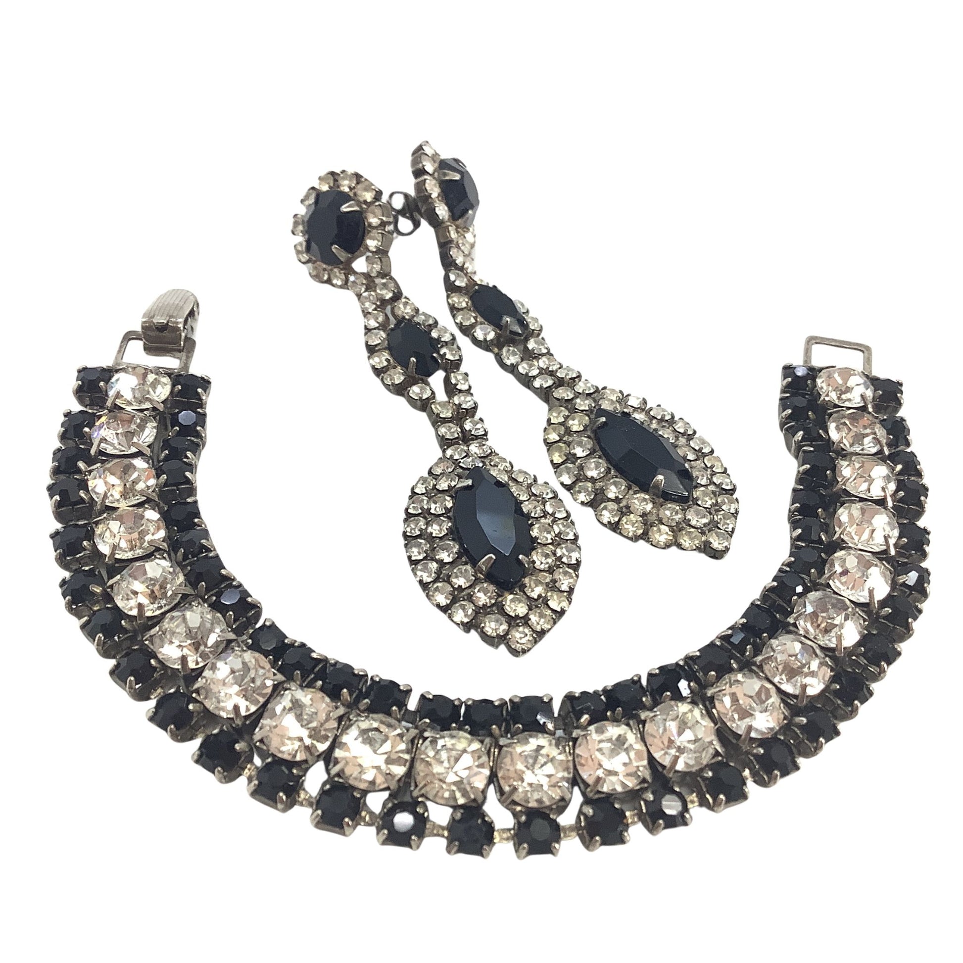 Jewelry set with necklace, bracelet, and earrings featuring black and clear stones on a white background