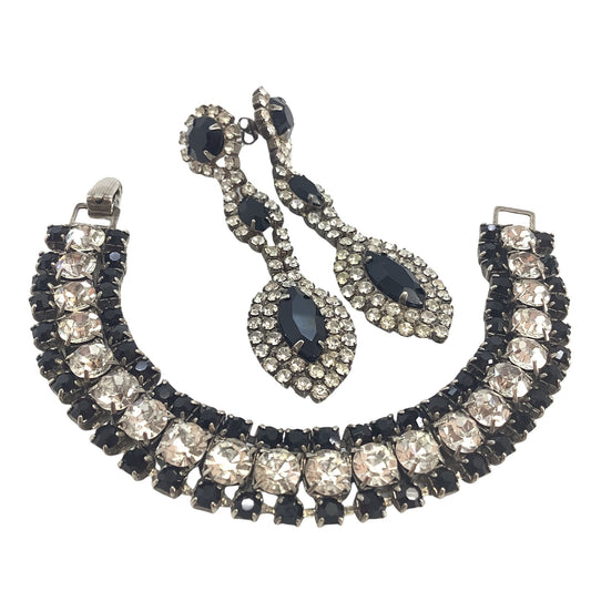 Jewelry set with necklace, bracelet, and earrings featuring black and clear stones on a white background
