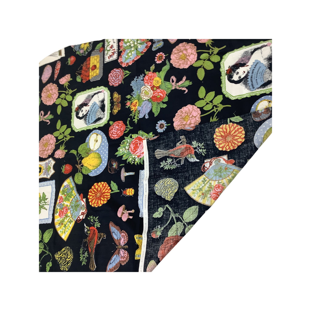 Gloria Vanderbilt fabric remnant folded and featuring a dense multicolor print with flowers, birds, butterflies, mushrooms, and framed illustrations on a black base.
