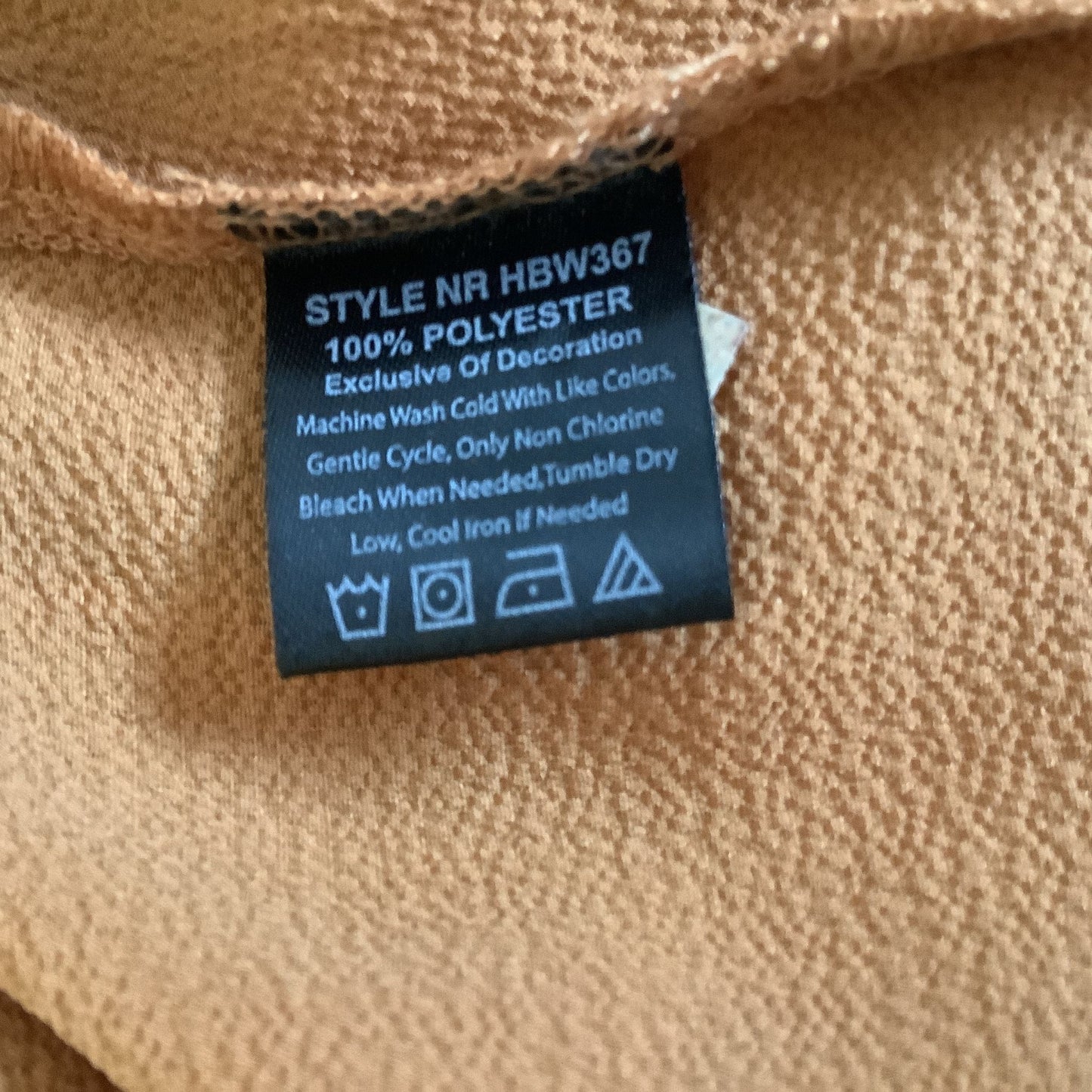 Fabric label on a mustard fabric with washing instructions.