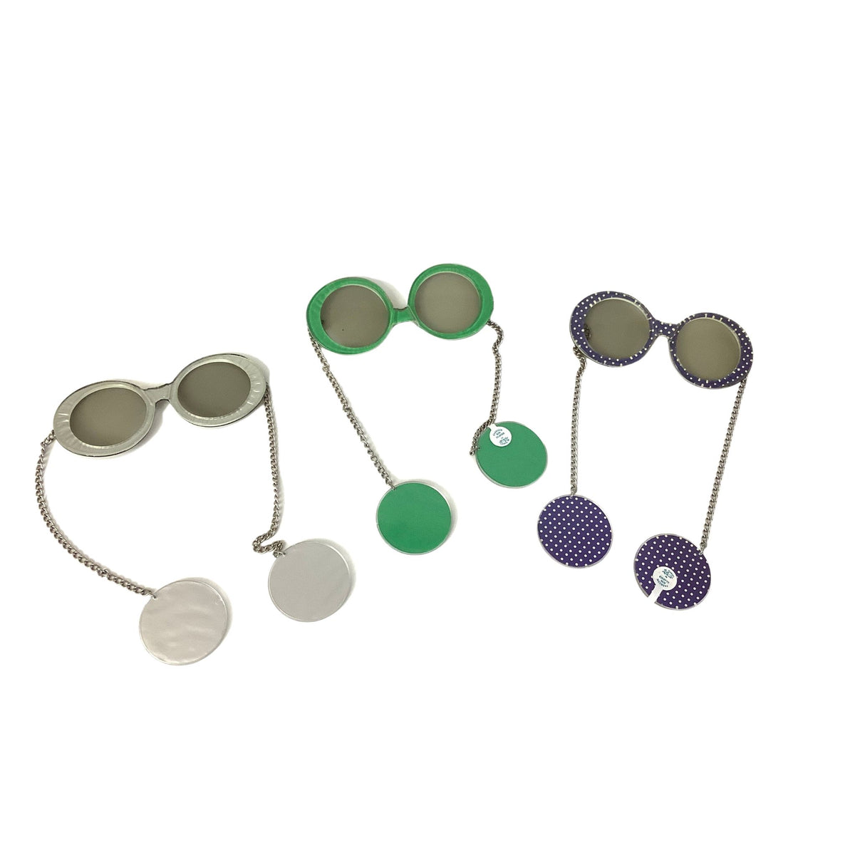 Three pairs of novelty Je-Dol sunglasses with attached circular earrings, shown on a plain white background. One pair is silver with a textured finish, one is bright green, and one is purple with white polka dots.