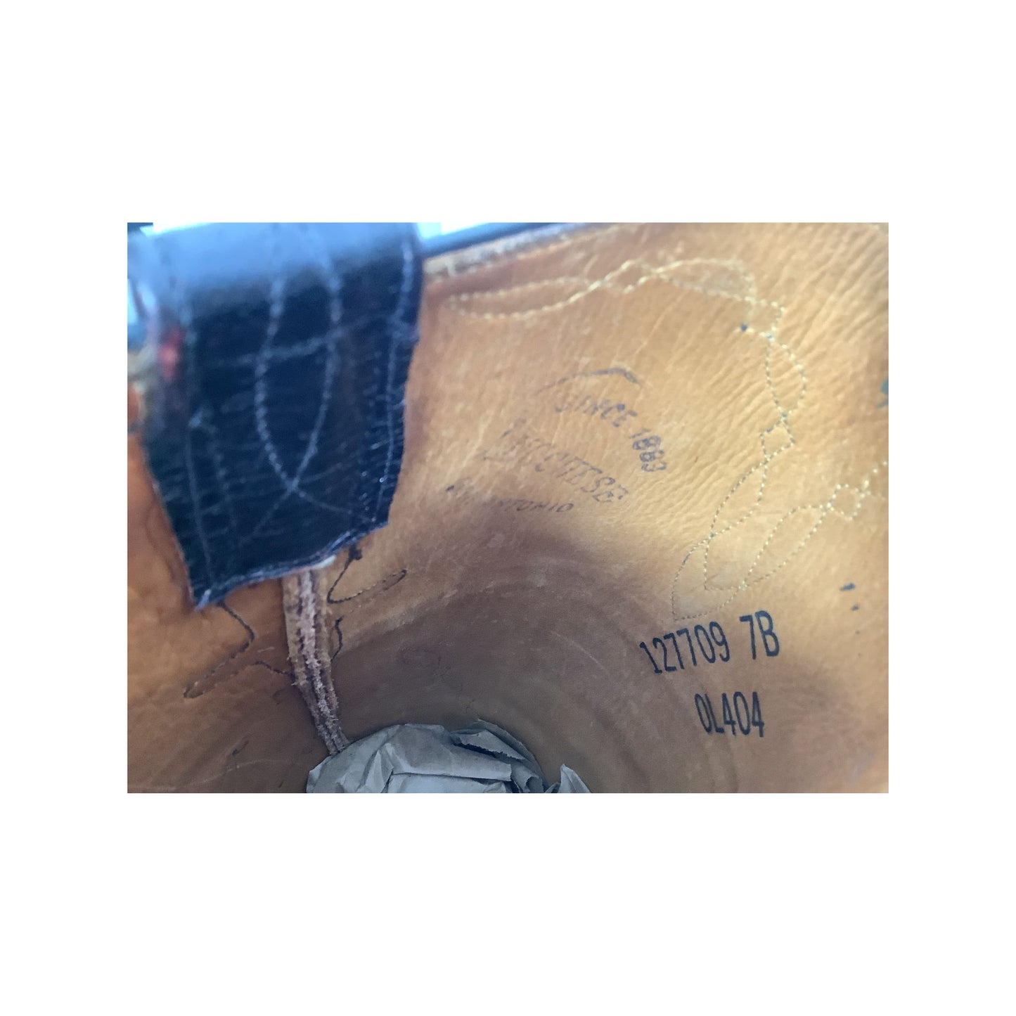 Close-up of the interior lining of a tan leather shoe or boot, showing printed Since 1883 Lucchese San Antonio.