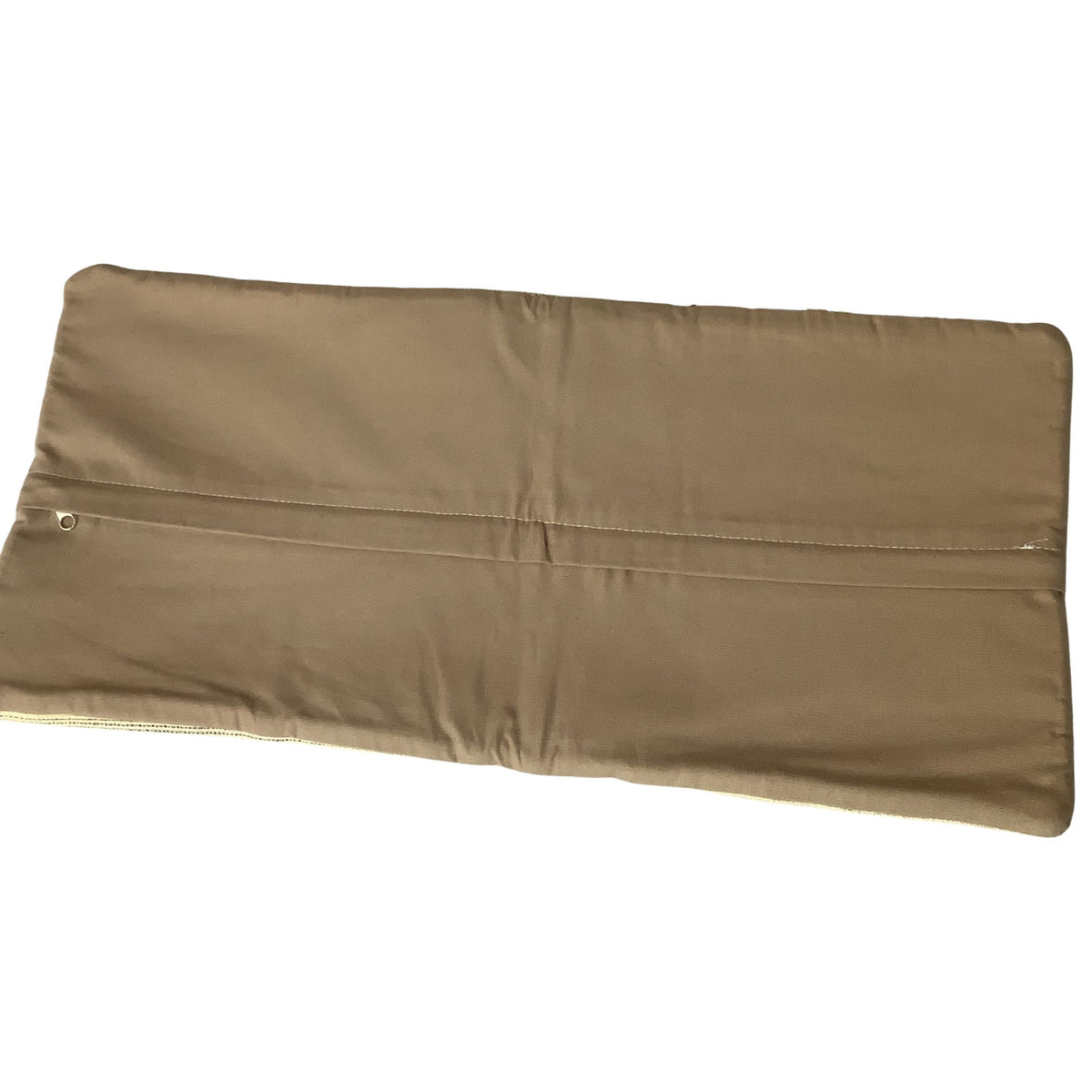 A tan-colored rectangular padded lumber pillow cover with a horizontal seam and a small metal zipper grommet on the left edge, shown against a plain white background