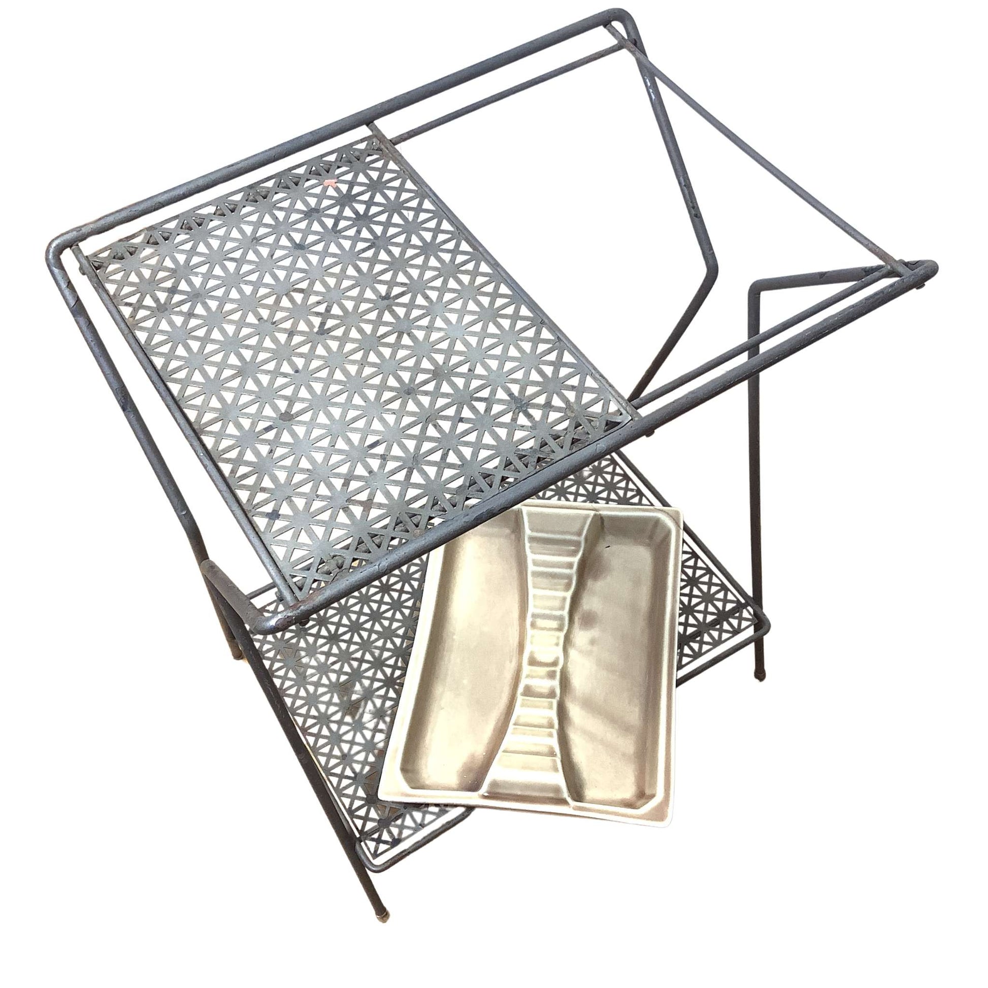 View of metal telephone table with ceramic ashtray on lower shelf on a white background