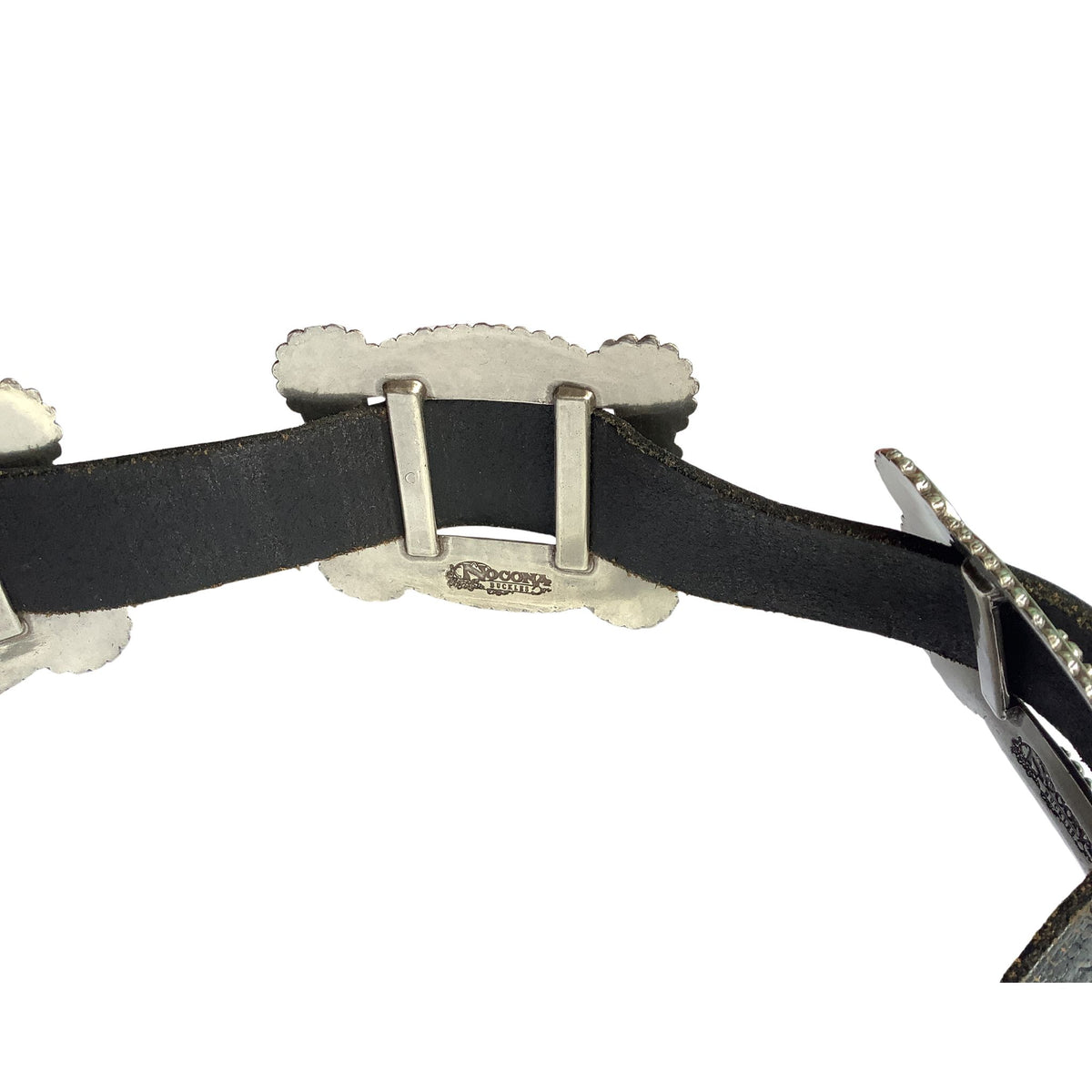 A close-up of a Nocona western-style belt featuring a black leather strap and ornate silver-tone metal conchos and studs, shown against a plain white background.