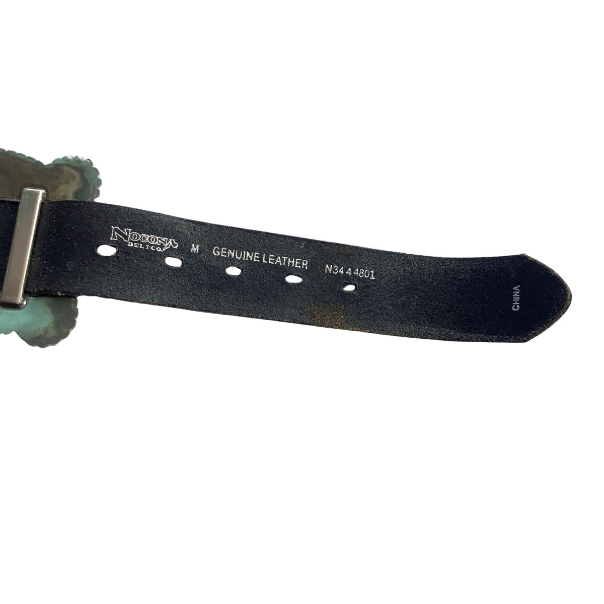 A close-up of a Nocona black genuine leather belt strap with silver-toned metal hardware and white printed text showing the brand 'Nocona' and size 'M'.