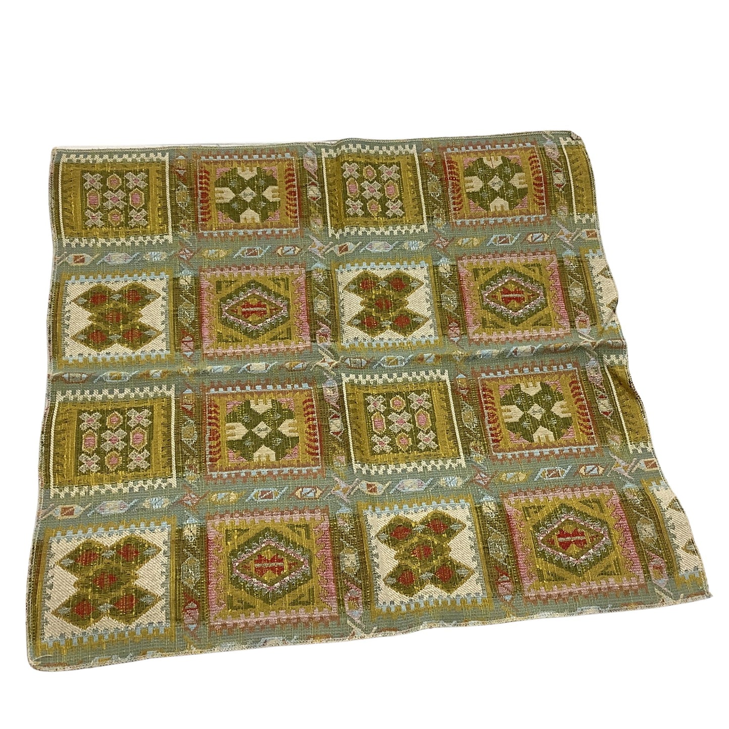 front view of a vintage fabric sample in a geometric patchwork pattern in olive green, beige, pink, and red.