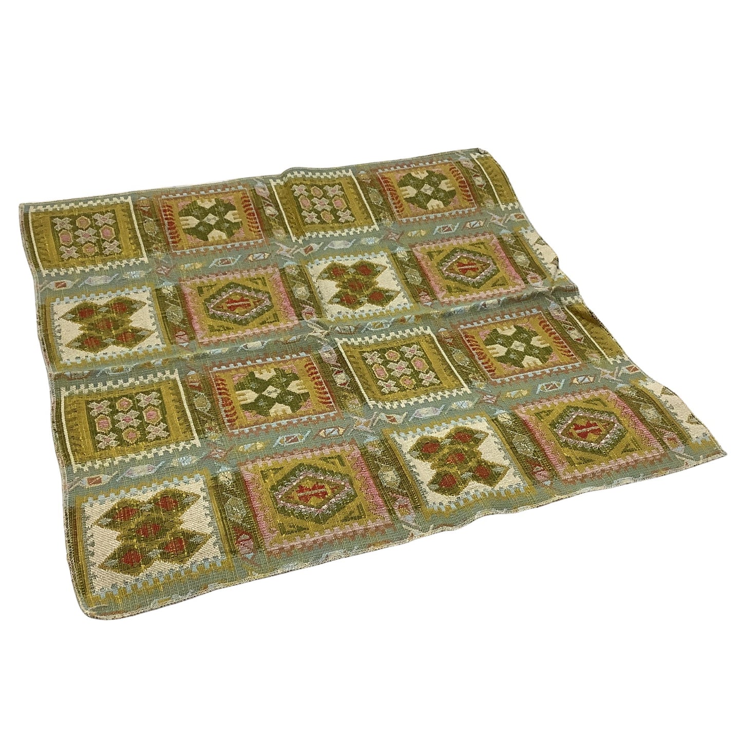 vintage patchwork-style geometric pattern fabric sample in muted olive green, beige, pink, and rust red.