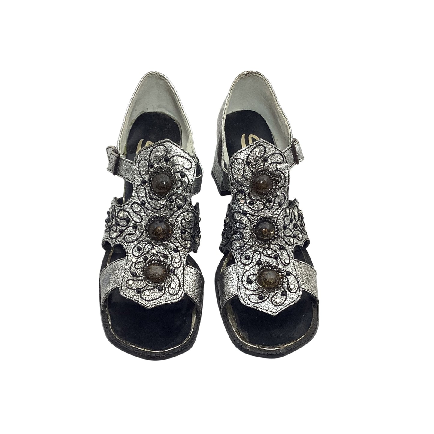Pair of silver sandals with decorative straps on a white background