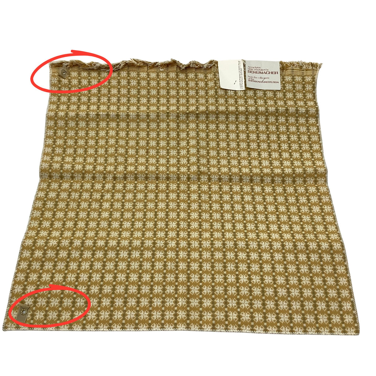 Vintage Schumacher fabric sample, featuring a repeating yellow geometric pattern. The top edge shows frayed fringe, and two red circles highlight grommets.