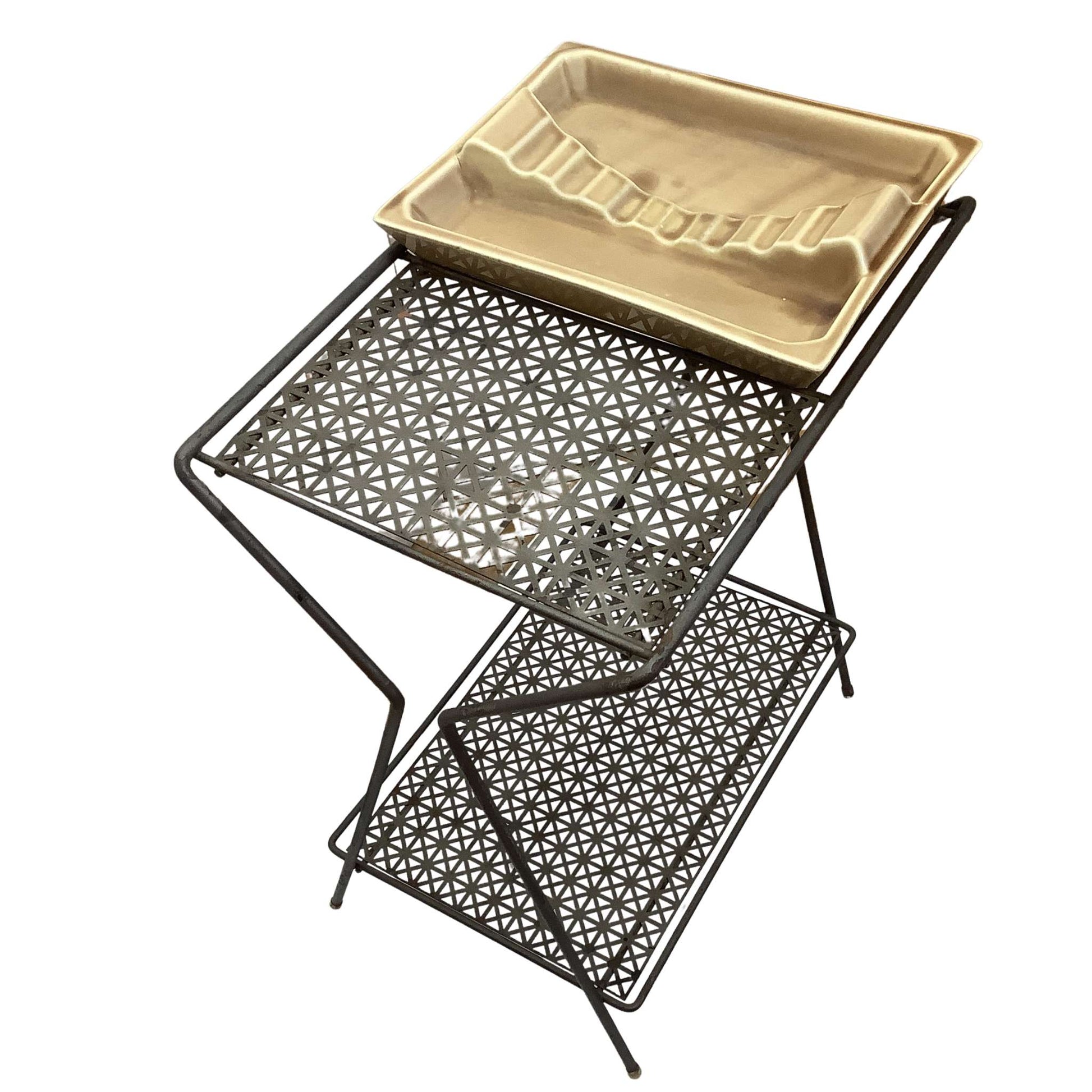 Top side view of metal table with geometric design on a white background