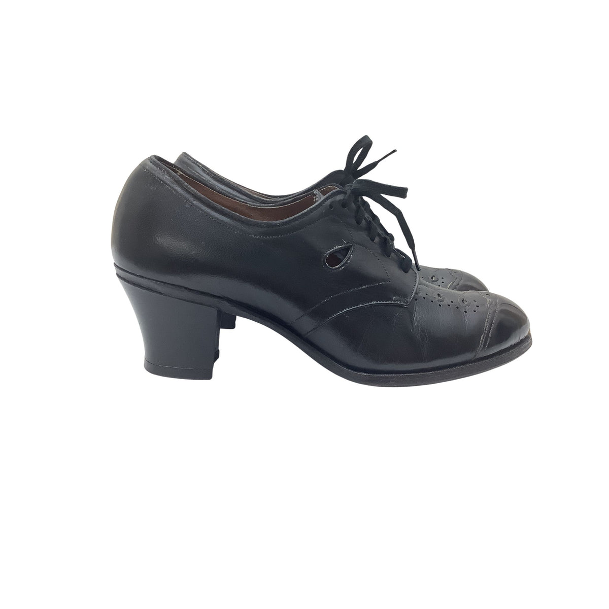 Pair of vintage Tread Easy black leather oxford-style shoe with a low block heel, laces, and decorative perforations on the toe, shown against a plain white background.