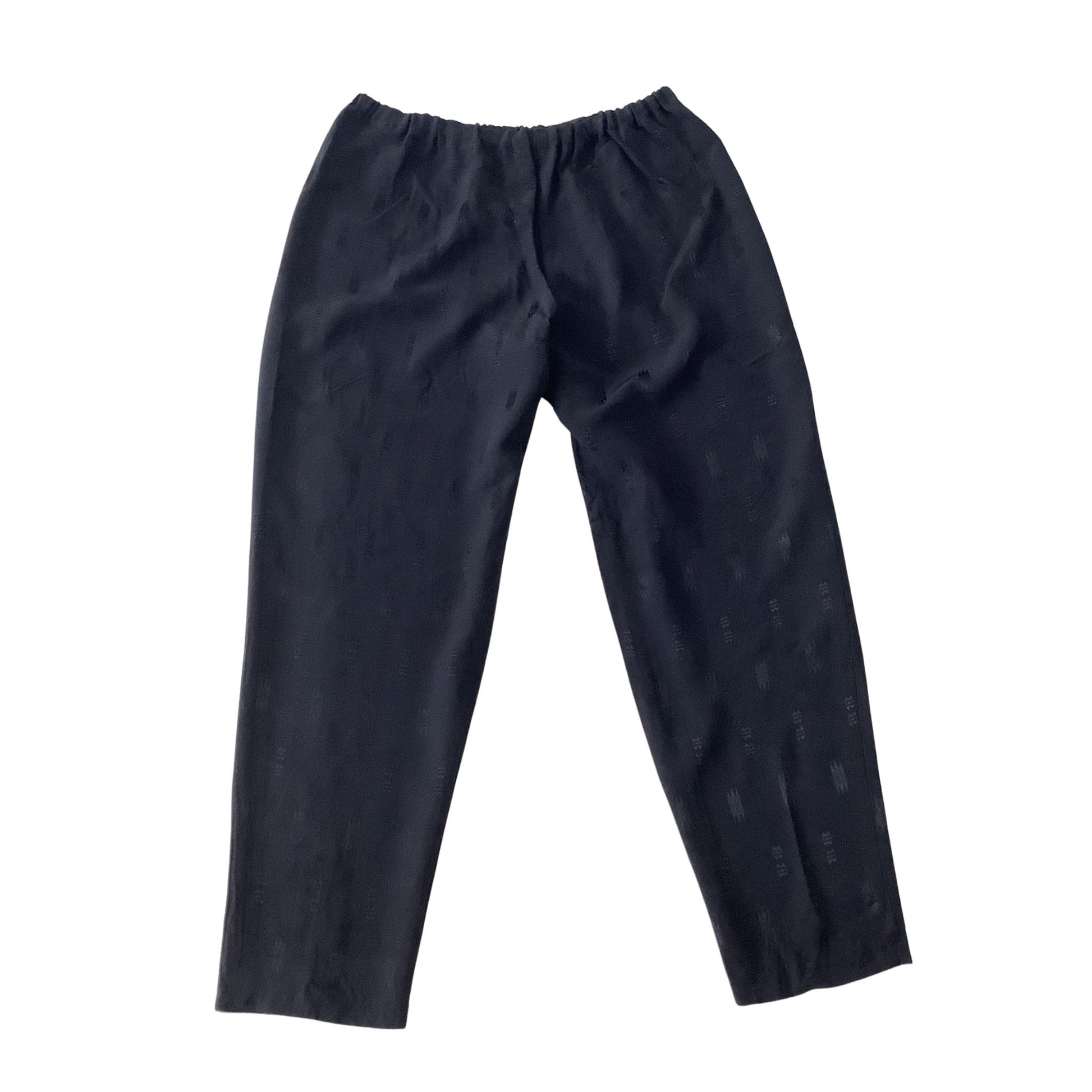 A pair of black pants with a subtle tonal pattern, featuring an elastic waistband and cropped legs, shown flat against a white background.