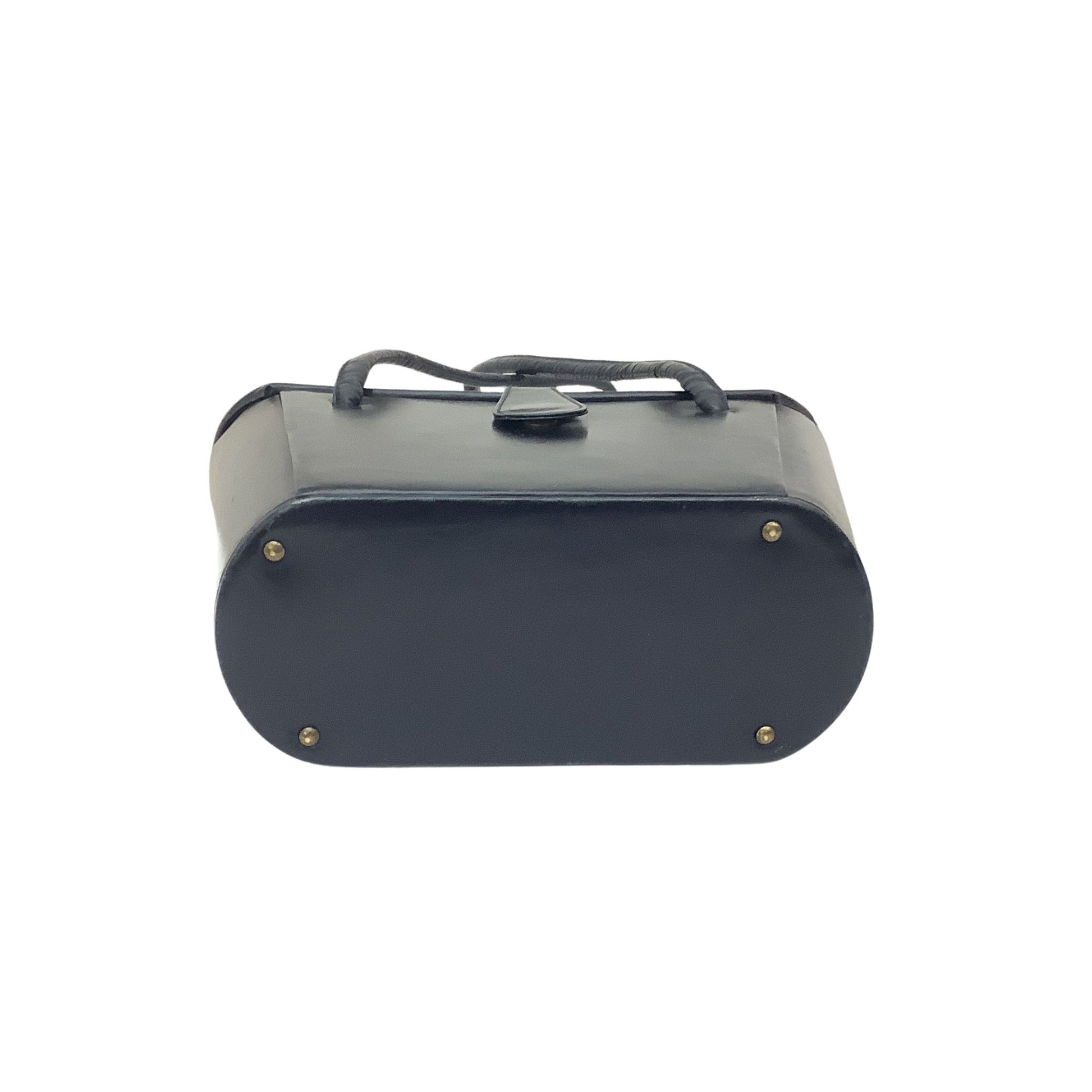 Bottom view of a navy blue handbag with a top handle partially visible