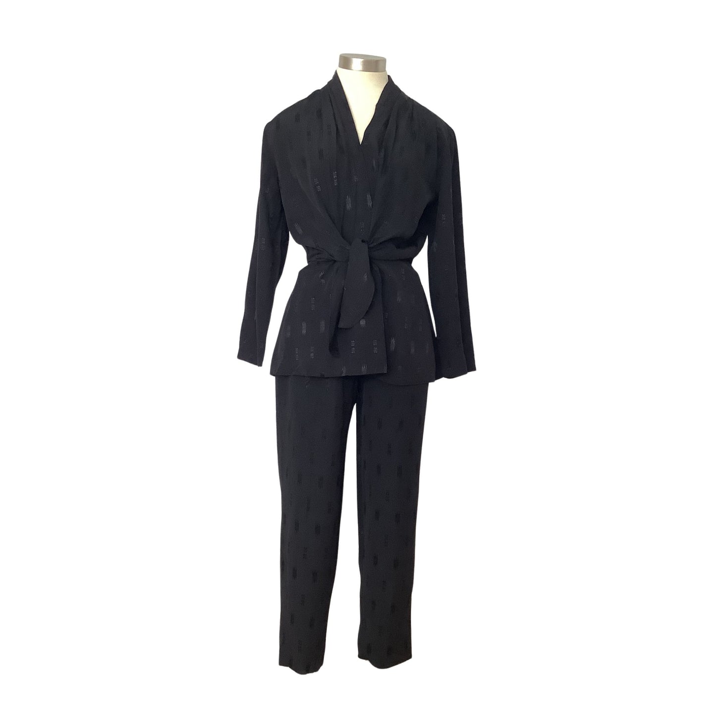 A black two-piece matching set consisting of a long-sleeve belted wrap jacket and matching trousers, displayed on a mannequin against a plain white background.
