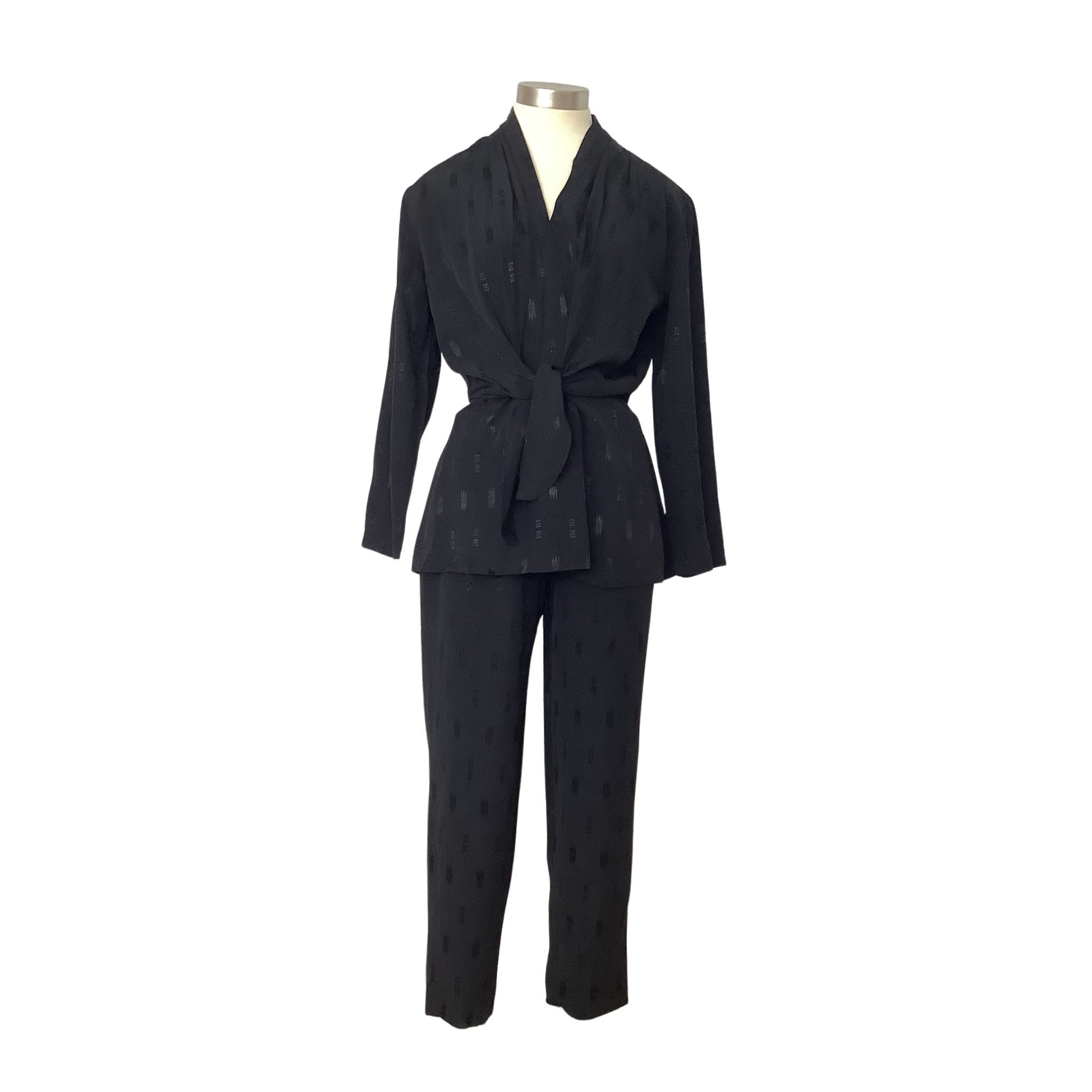 A black two-piece matching set consisting of a long-sleeve belted wrap jacket and matching trousers, displayed on a mannequin against a plain white background.