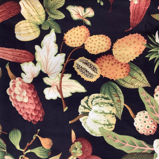 A close-up of a botanical fabric pattern featuring pumpkins, gourds, and leaves in muted orange, green, pink, and cream tones on a dark navy background.