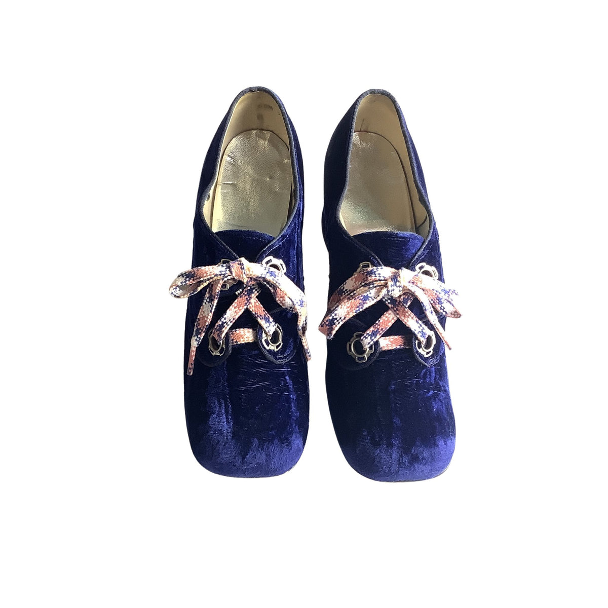 Pair of blue velvet shoes with decorative shoe laces on a white background