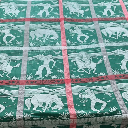 Top view of Cannon vintage western bedspread cowboys and indians motif in green and white with red accents.
